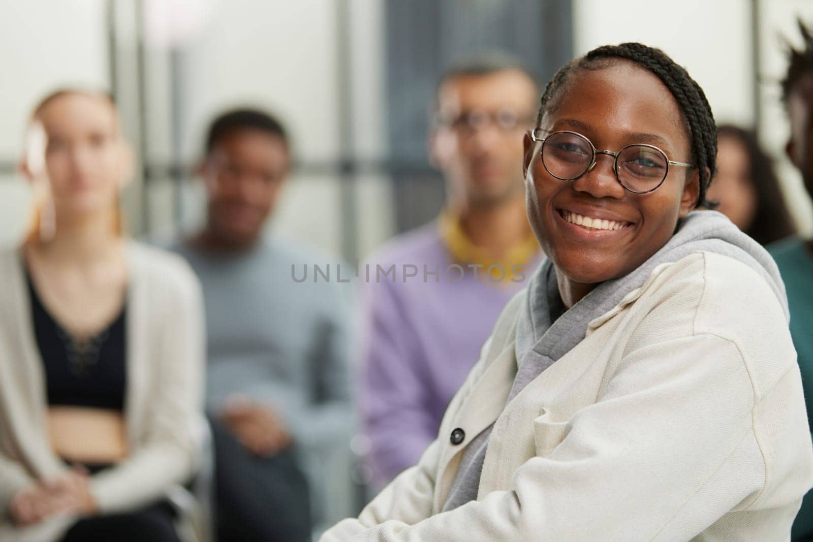 Thoughtful african american female freelancer looking at camera in front of her colleagues