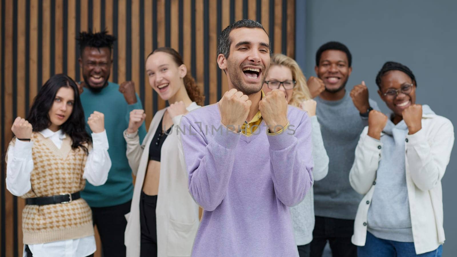 Happy people raise their hands up clenching their fists. Success concept
