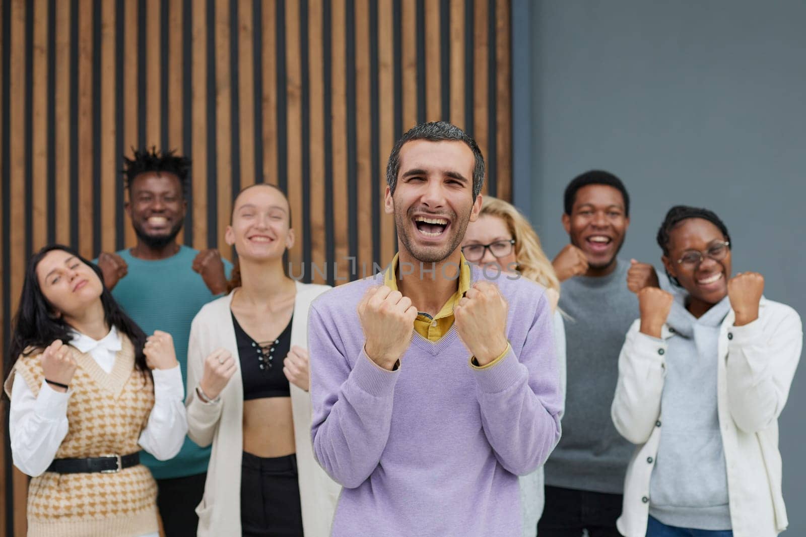 Happy people raise their hands up clenching their fists. Success concept