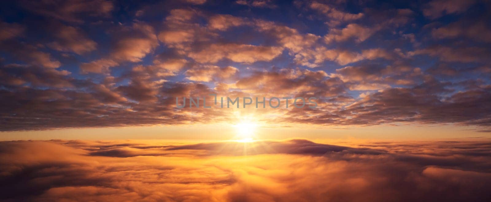 Wide panorama of setting sun above the clouds by VitaliiPetrushenko