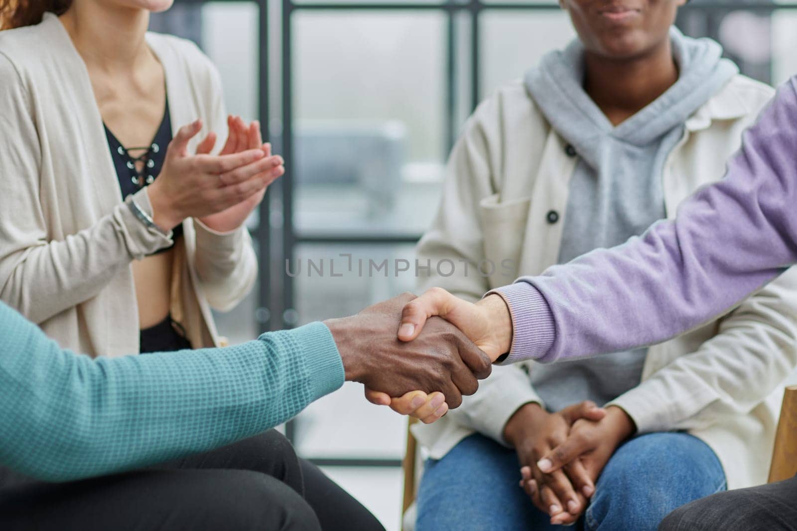 close up. smiling guy shaking hands with his friend