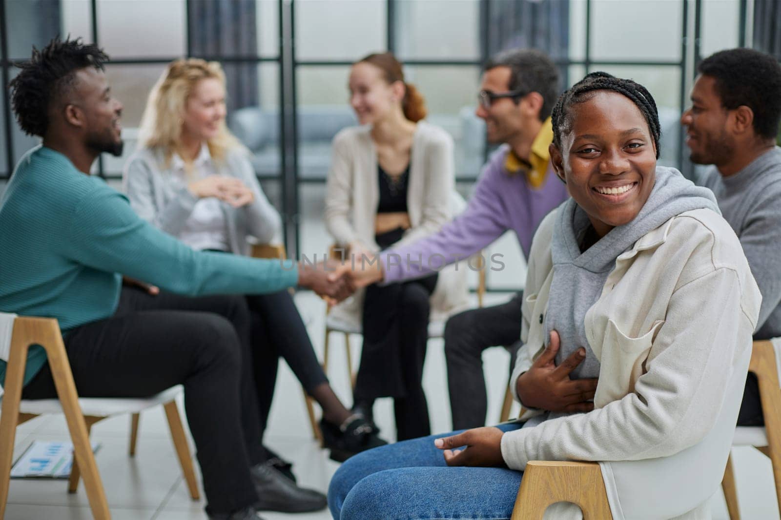 Successful African American manager sitting in front of her colleagues