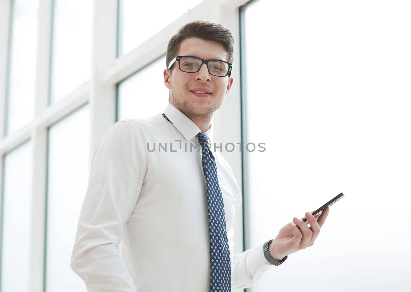 Businessman using smart phone in blurred office space background and copy space