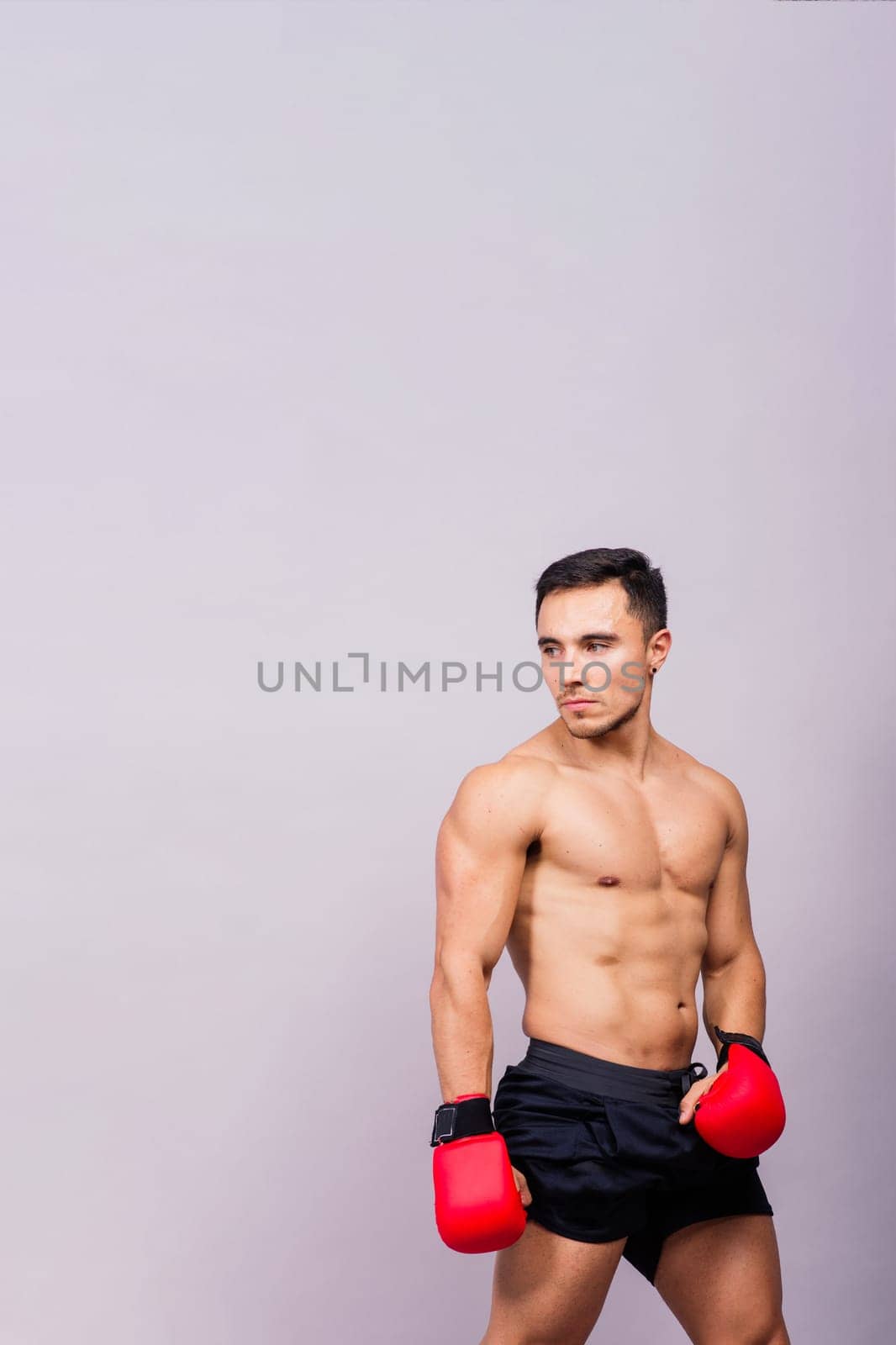 Boxing gloves, man training in sports fight, challenge or mma competition on studio background. by Zelenin