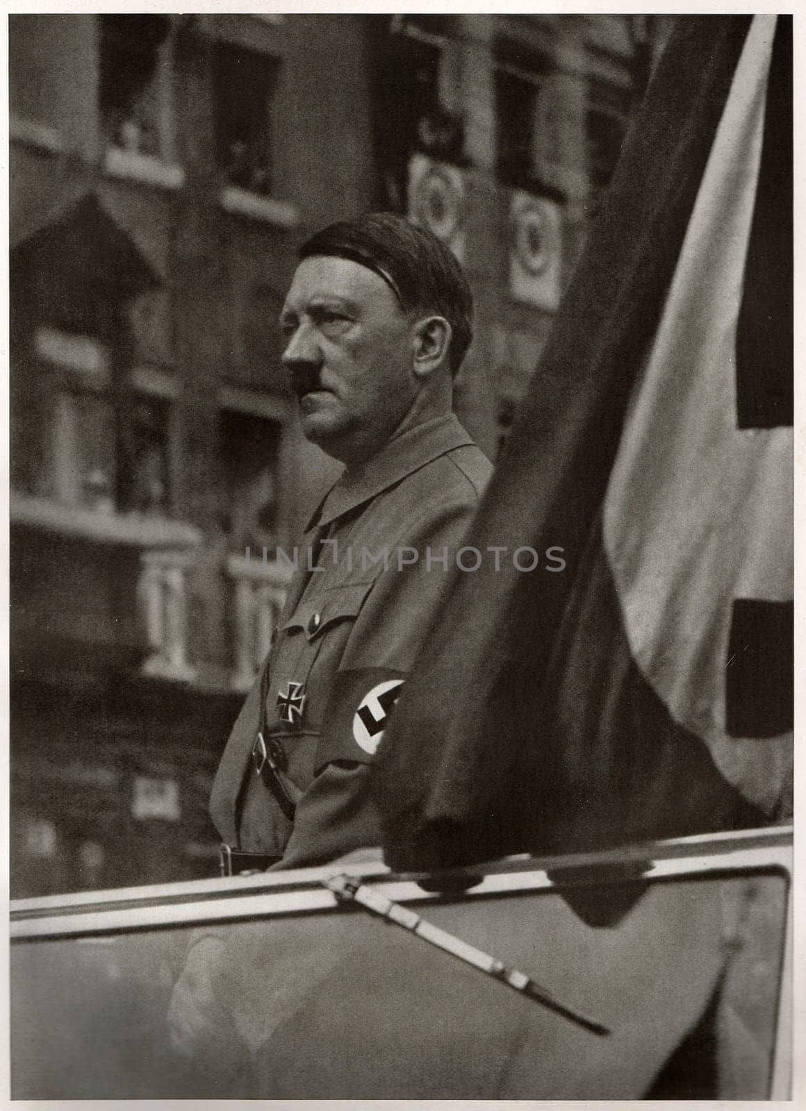 GERMANY - 1937: German leader Adolf Hitler stands in his convertible. Reproduction of antique photo.