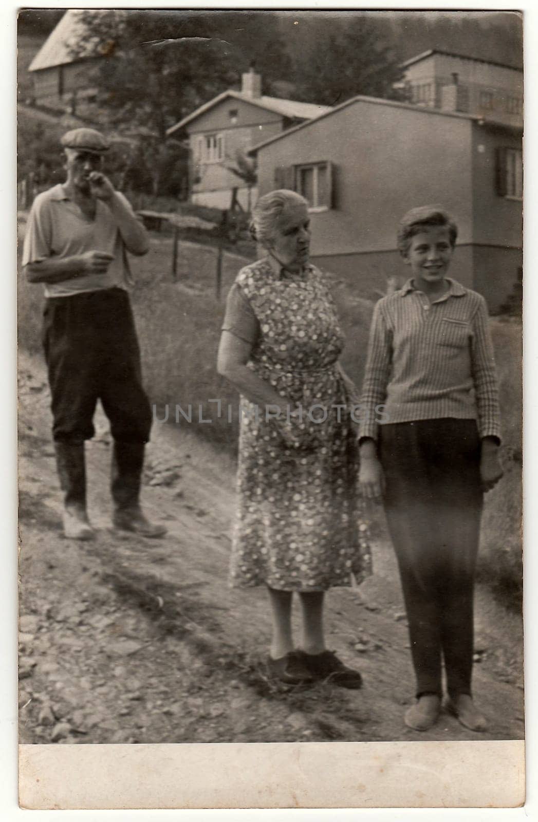 Vintage photo shows grandparents and their grandson in the village. by roman_nerud