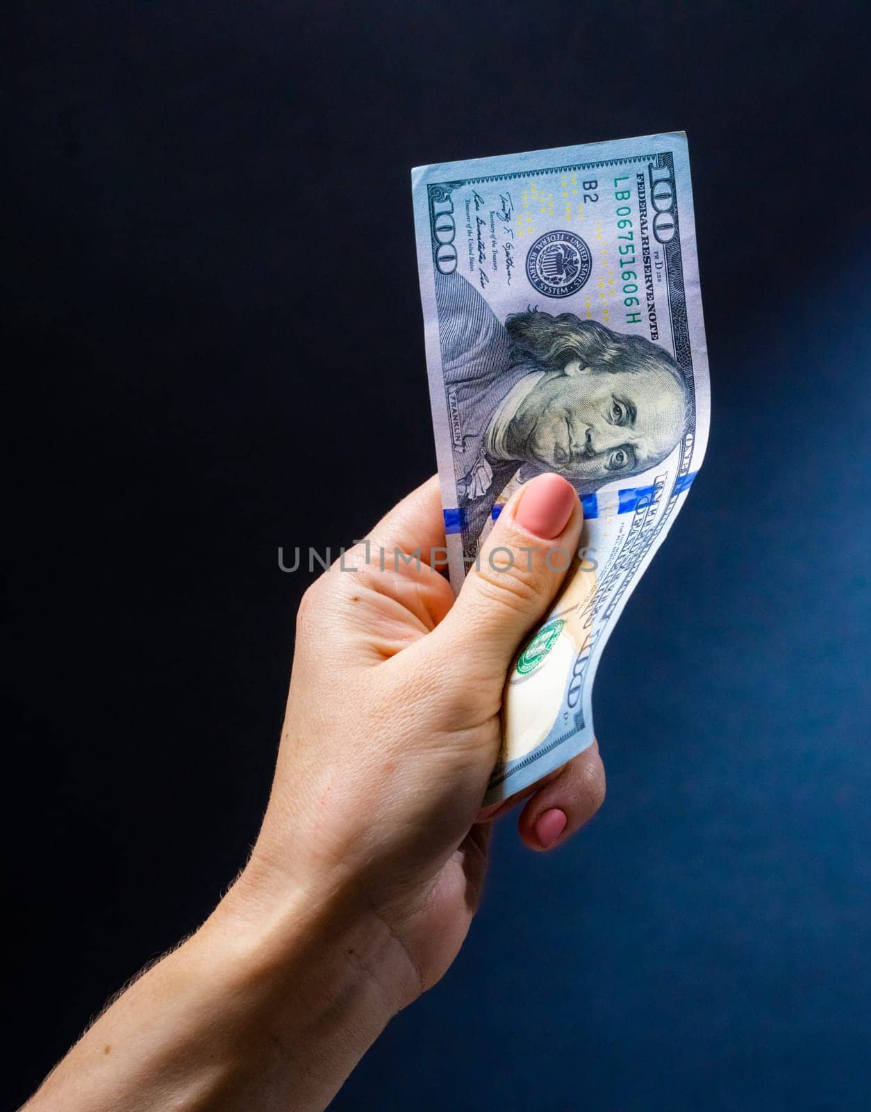 Hand holding one hundred dollar banknote. American USA currency in cash as symbol of success and wealth