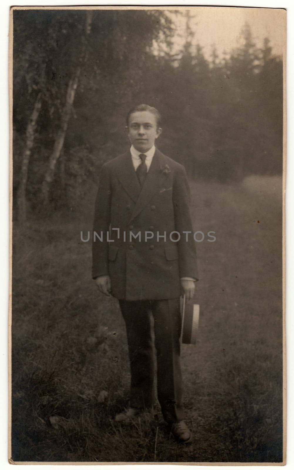 Vintage photo shows man holds wide-brimmed hat. Antique black white photo. by roman_nerud