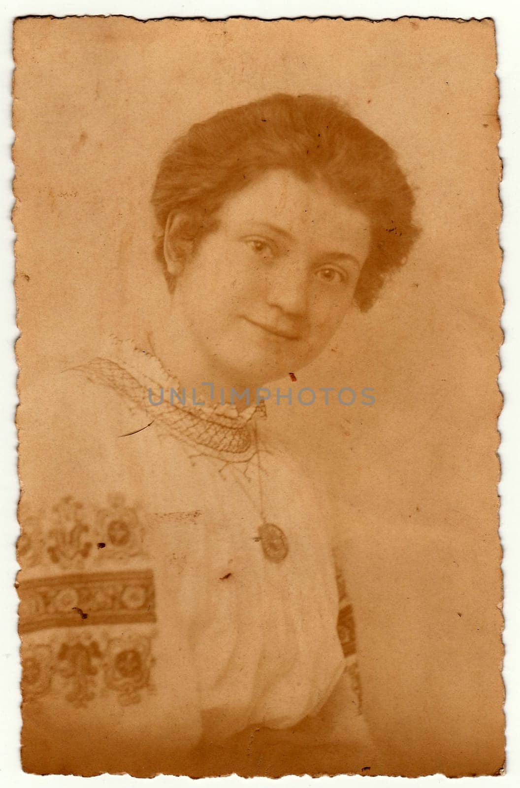 Vintage photo shows young woman wears a folk blouse with floral pattern Sunday best dress . Antique black white studio portrait. by roman_nerud
