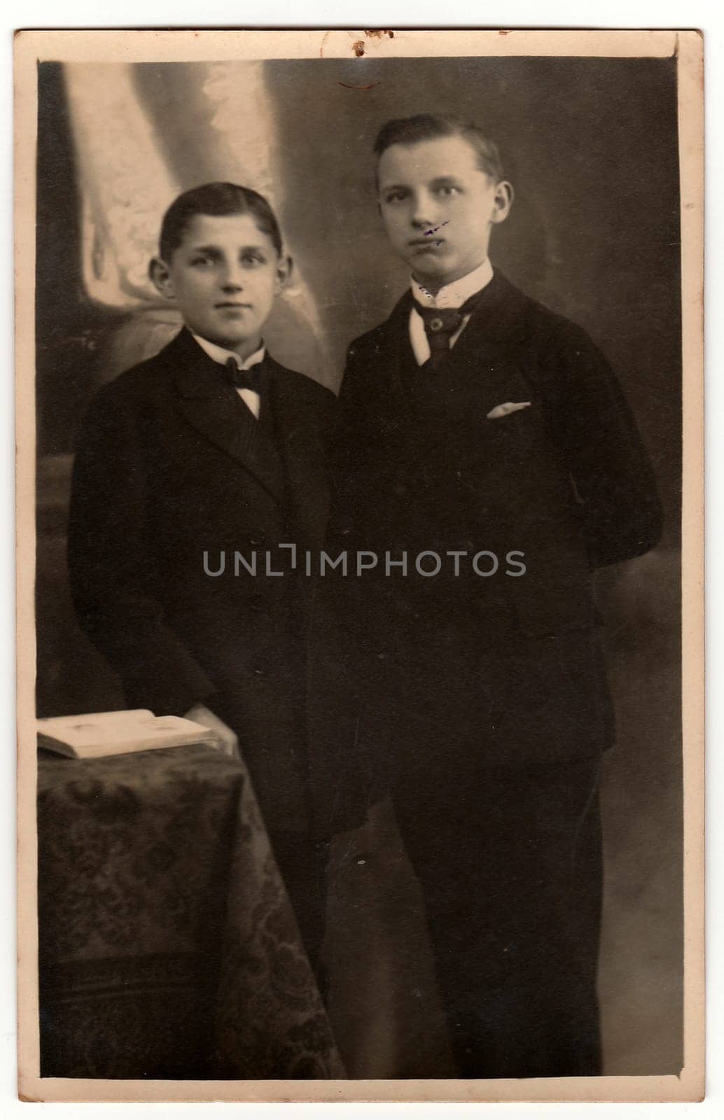 THE CZECHOSLOVAK REPUBLIC - CIRCA 1920s: Vintage photo shows boys wear jackets with handkerchief in the pocket. Antique black white studio portrait. On top of image is imprint of drawing pin.