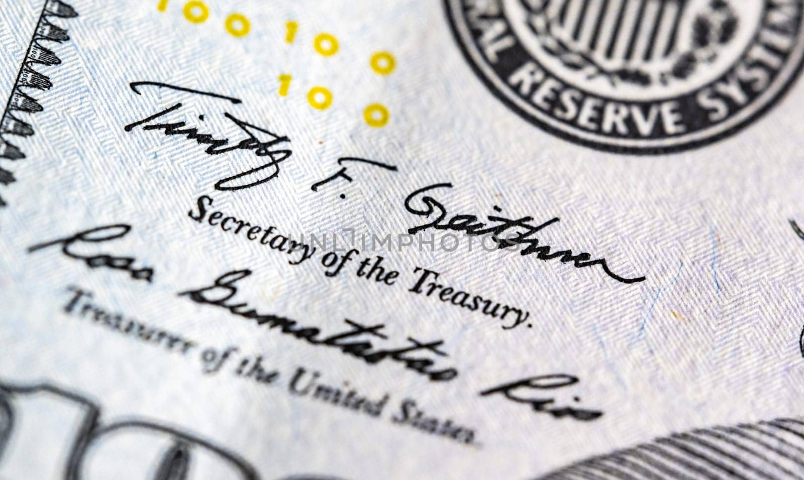 Close up macro view of one hundred American dollars bill fragment with treasuruty sign. United States currency.
