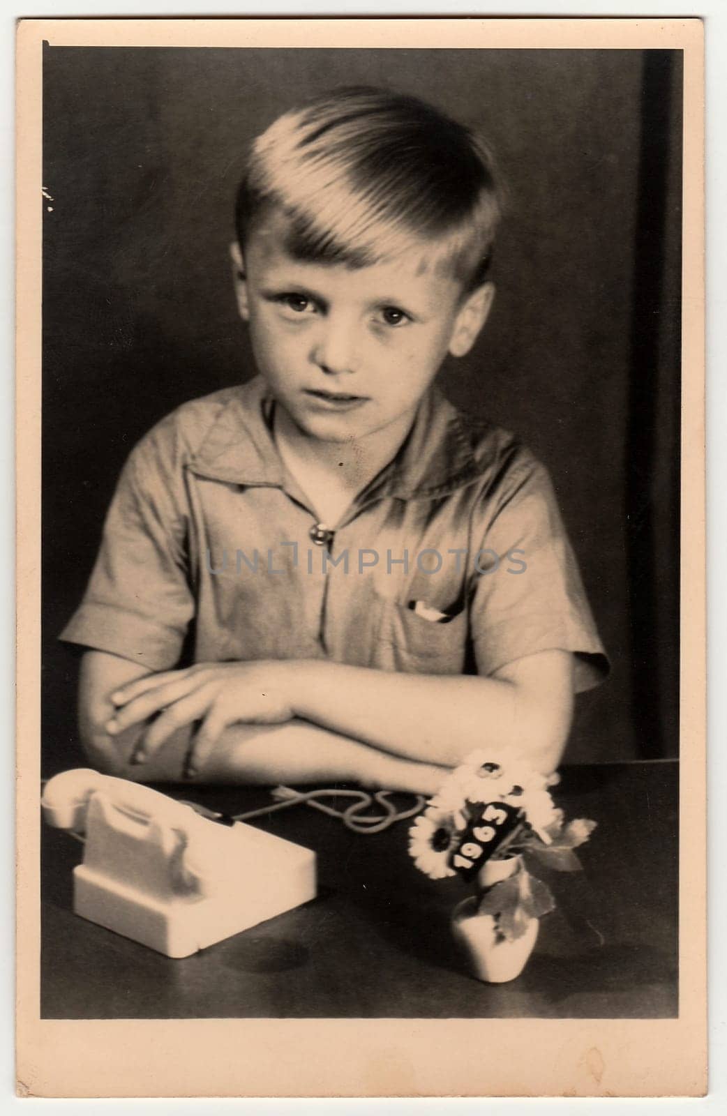 Vintage photo shows a young boy with children's telephone. Black white retro photo. by roman_nerud