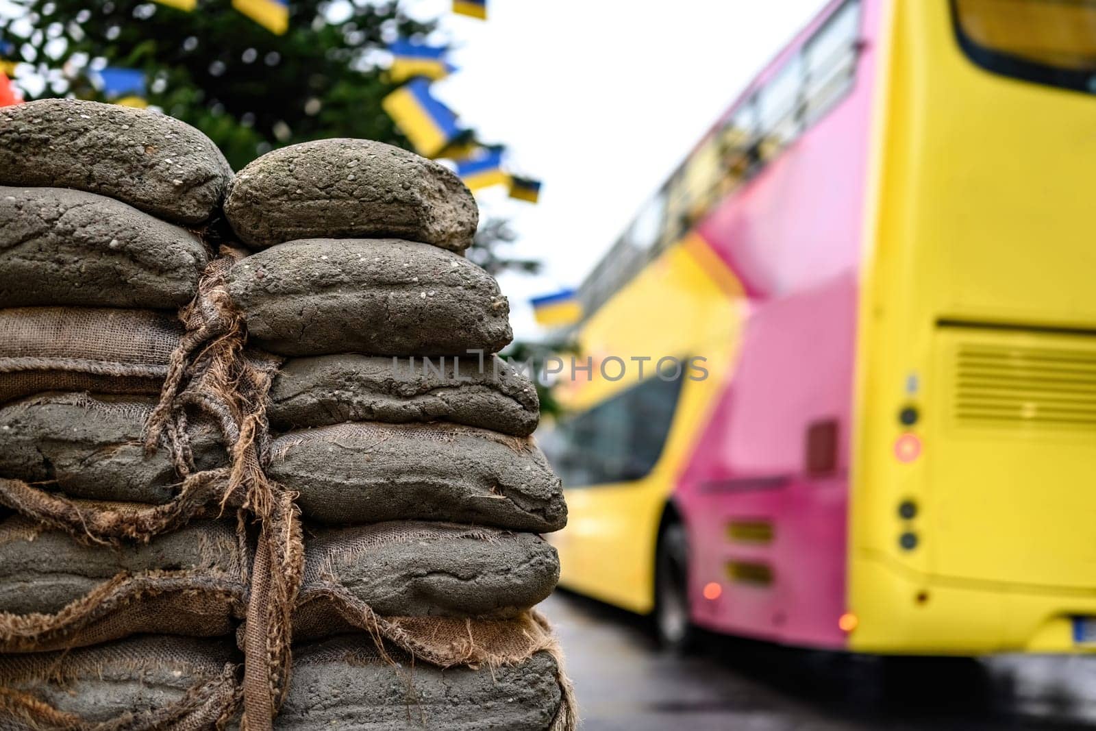 Sacks with sand at Checkpoint Charlie against hop-on hop-off touristic bus. The crossing point between East and west Berlin, symbol of the Cold War.