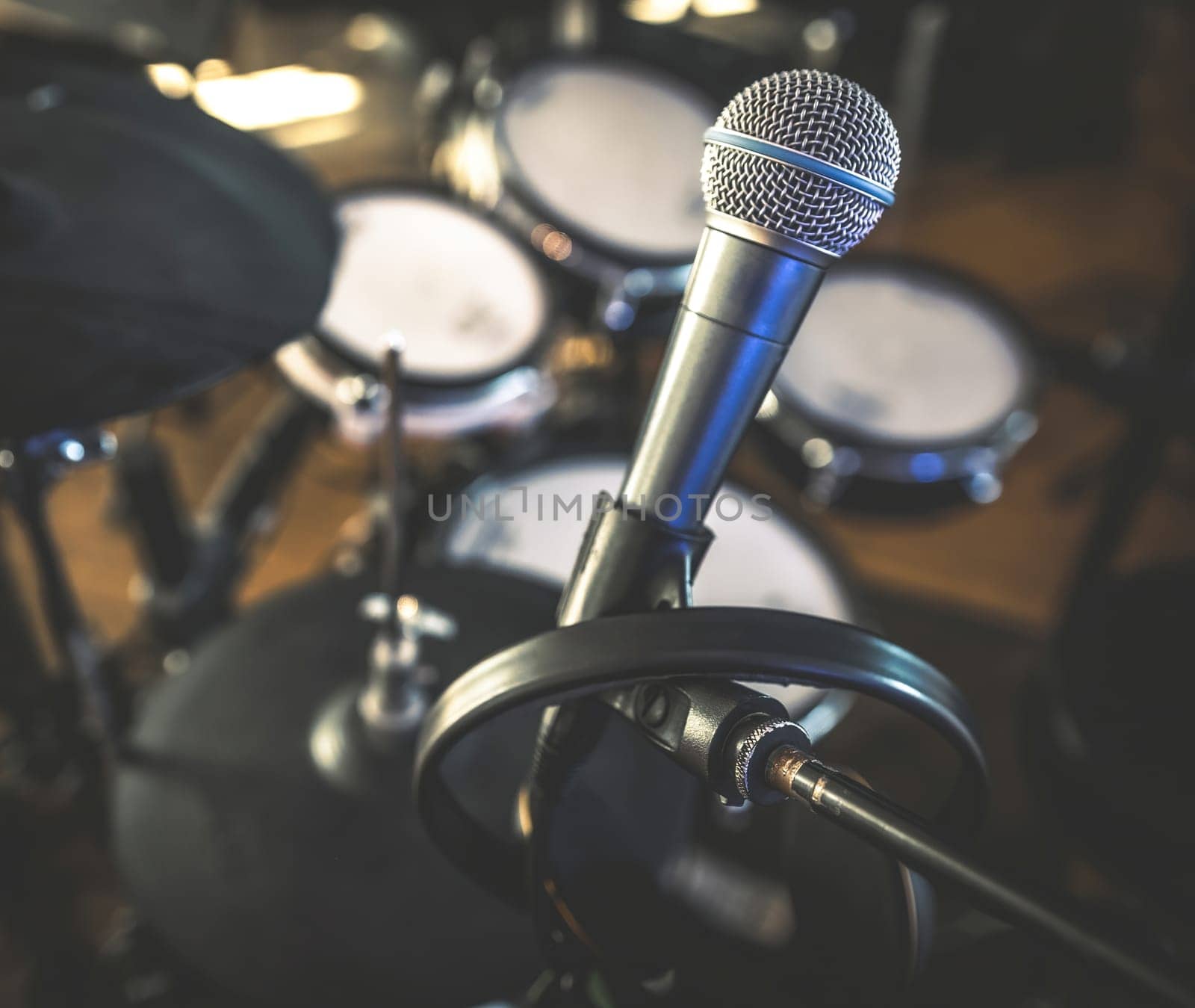 Microphone and drums in recording studio for live music perfomance closeup. Mic stage for rock and pop vocal presentation