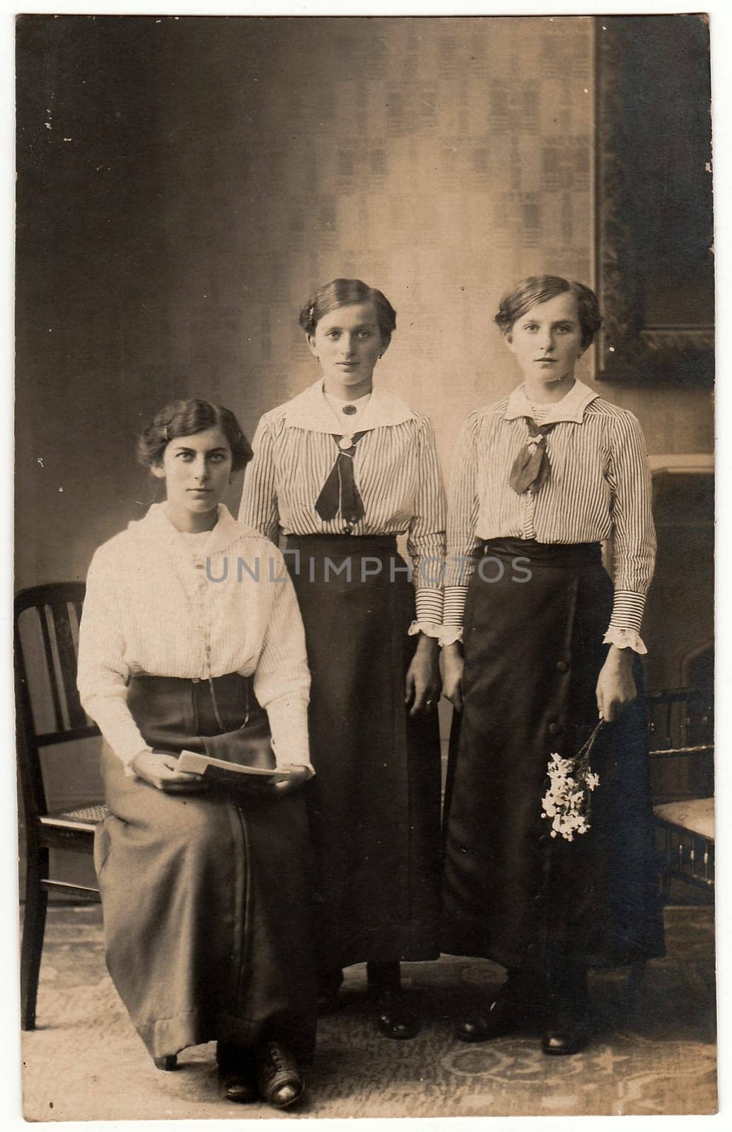 SOLINGEN, GERMANY - CIRCA 1920s: Vintage photo shows three women pose for photohrapher. Black & white photo with sepia tint.