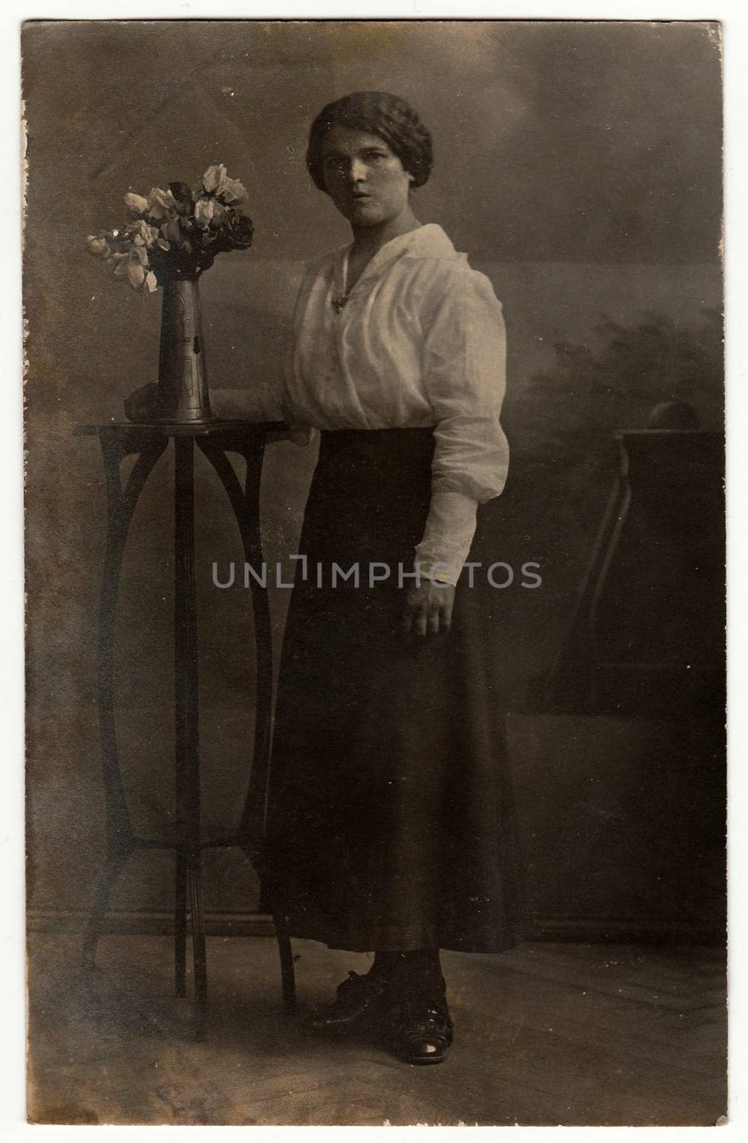 Vintage photo shows woman poses in a photography studio. Black white antique studio portrait. by roman_nerud
