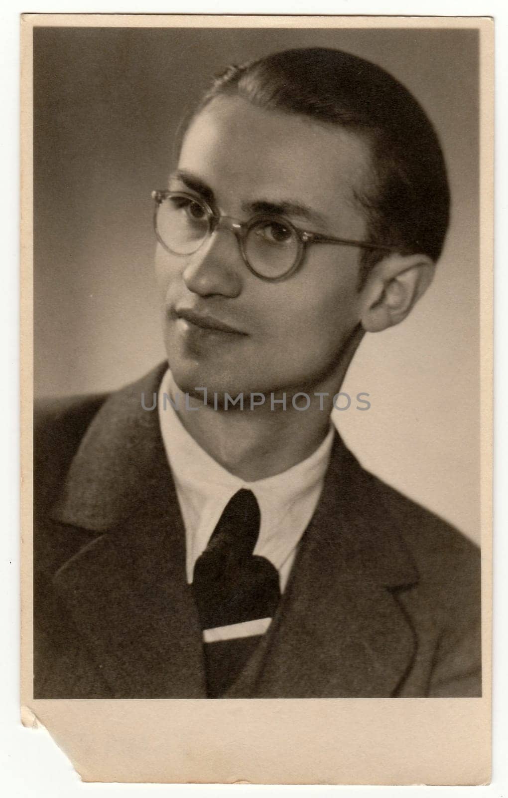 THE CZECHOSLOVAK REPUBLIC - CIRCA 1940s: Vintage photo shows young man with glasses. Black white antique studio portrait.