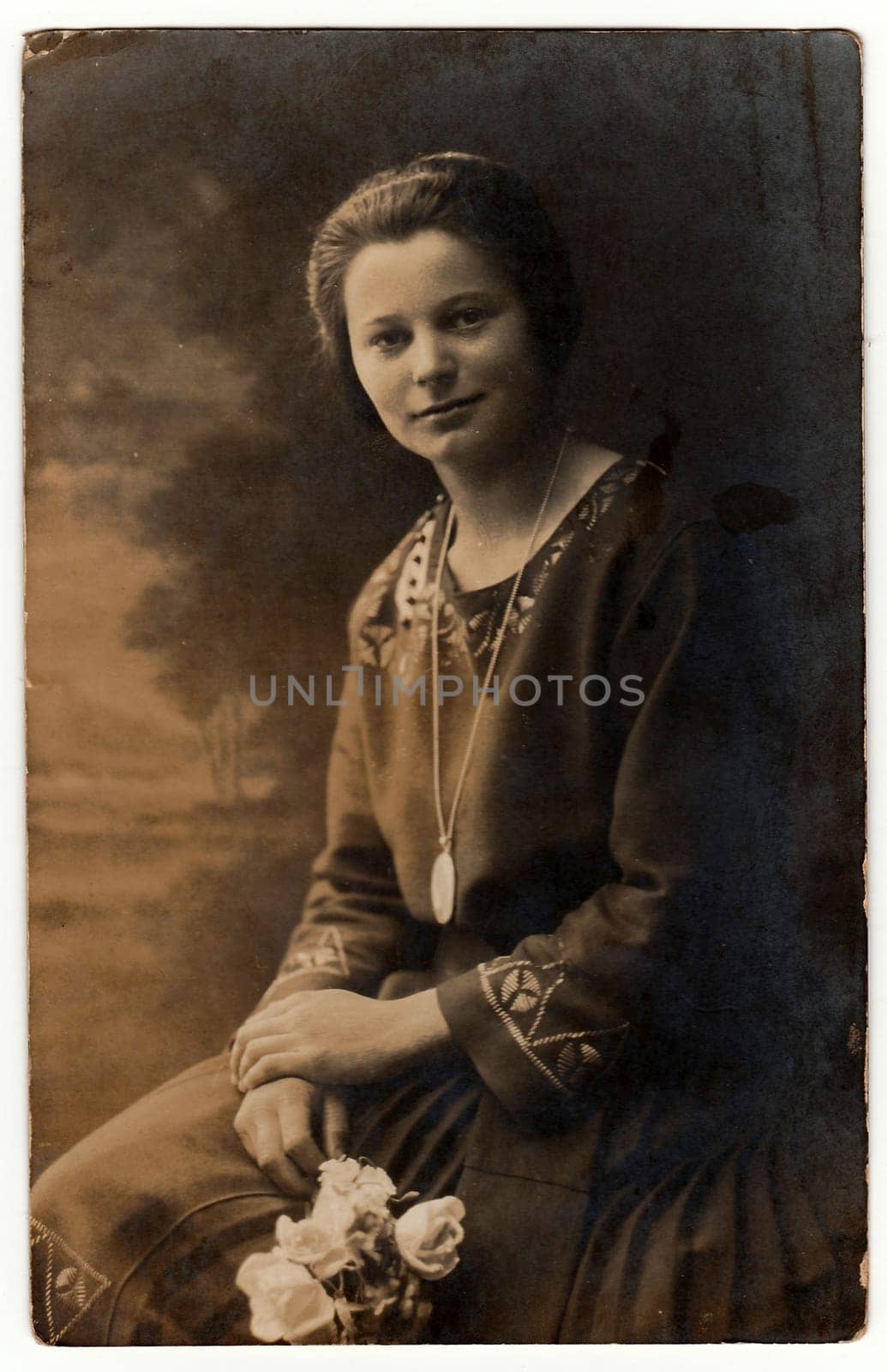 Vintage photo shows woman holds white roses. Photo with dark sepia tint. Black white studio portrait. by roman_nerud