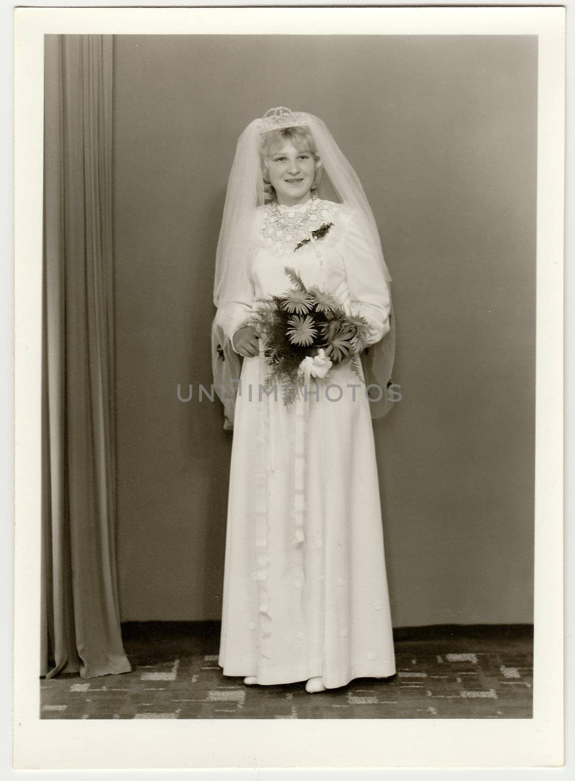 Vintage photo shows bride wears veil and she holds bouquet of gerberas. Black white antique photo. by roman_nerud