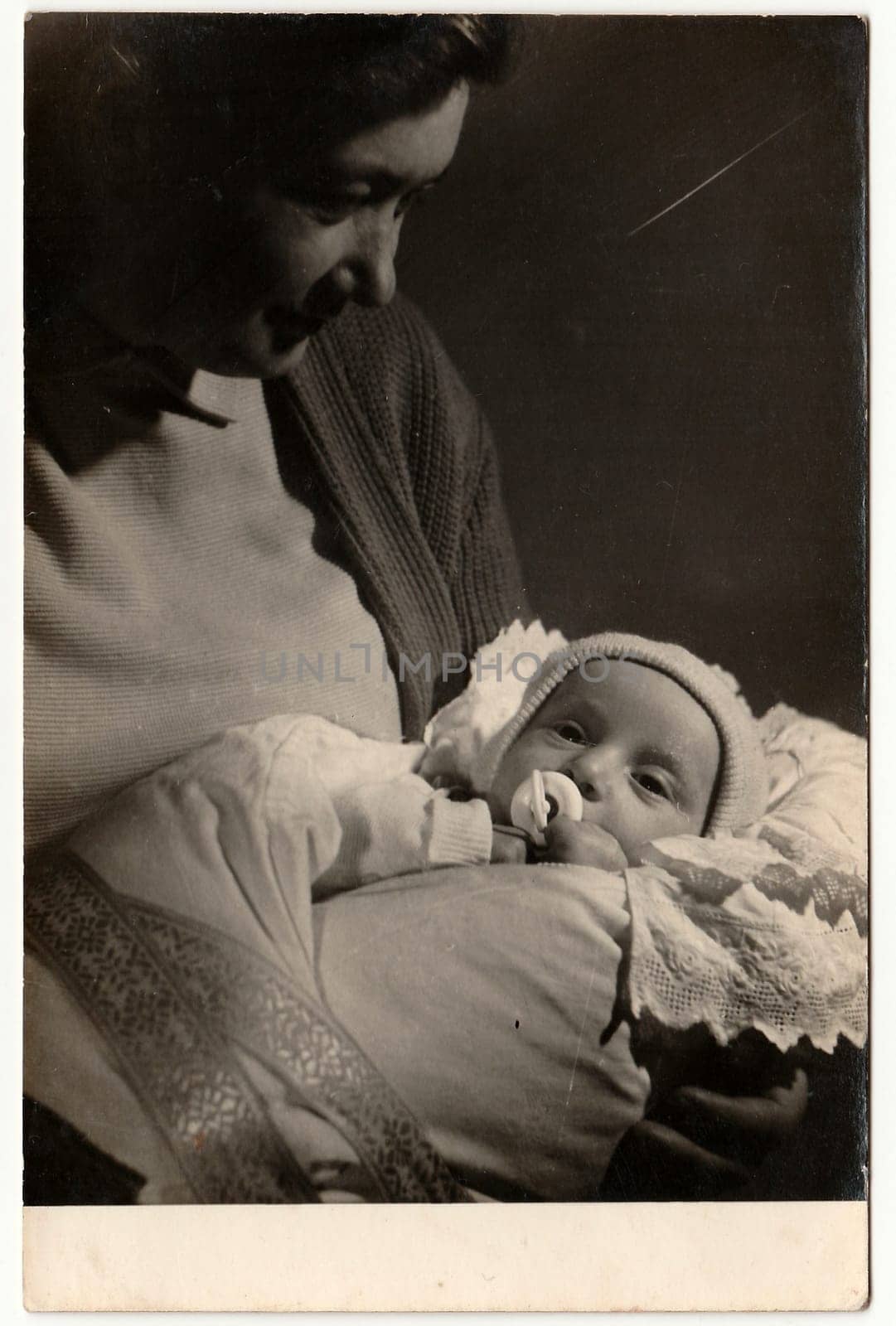 THE CZECHOSLOVAK SOCIALIST REPUBLIC - CIRCA 1960s: Vintage photo shows mother cradles her baby. Black white antique photo.