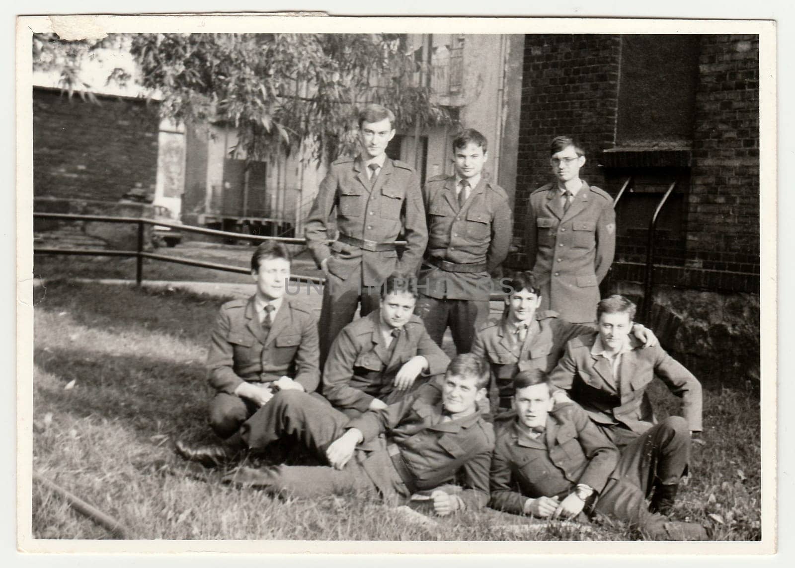 THE CZECHOSLOVAK SOCIALIST REPUBLIC - CIRCA 1970s: Vintage photo shows soldiers pose in front of barracks. Black white antique photo.