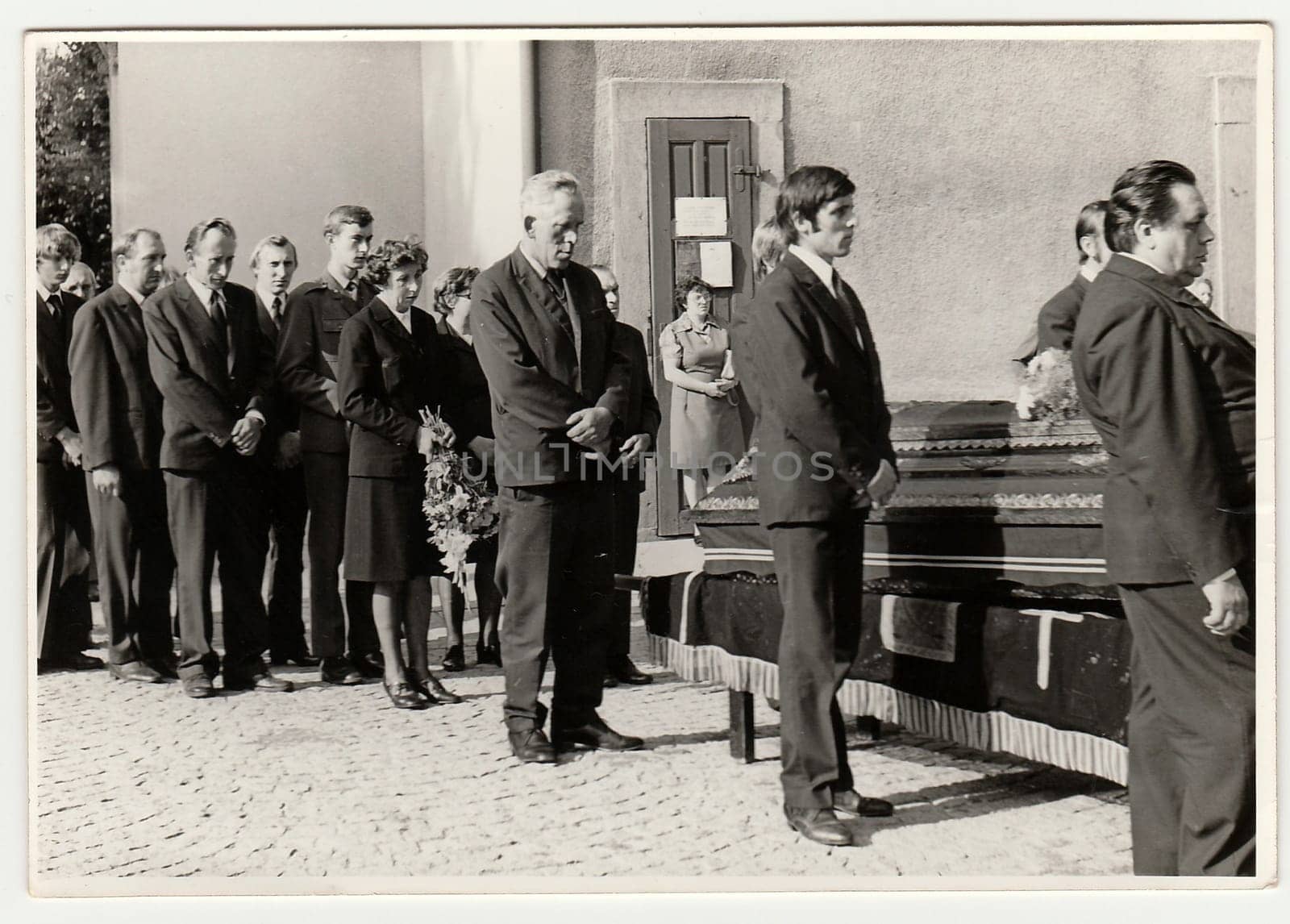 Vintage photo shows people during funeral. The coffin lies on bier next to church. Black white antique photo. by roman_nerud