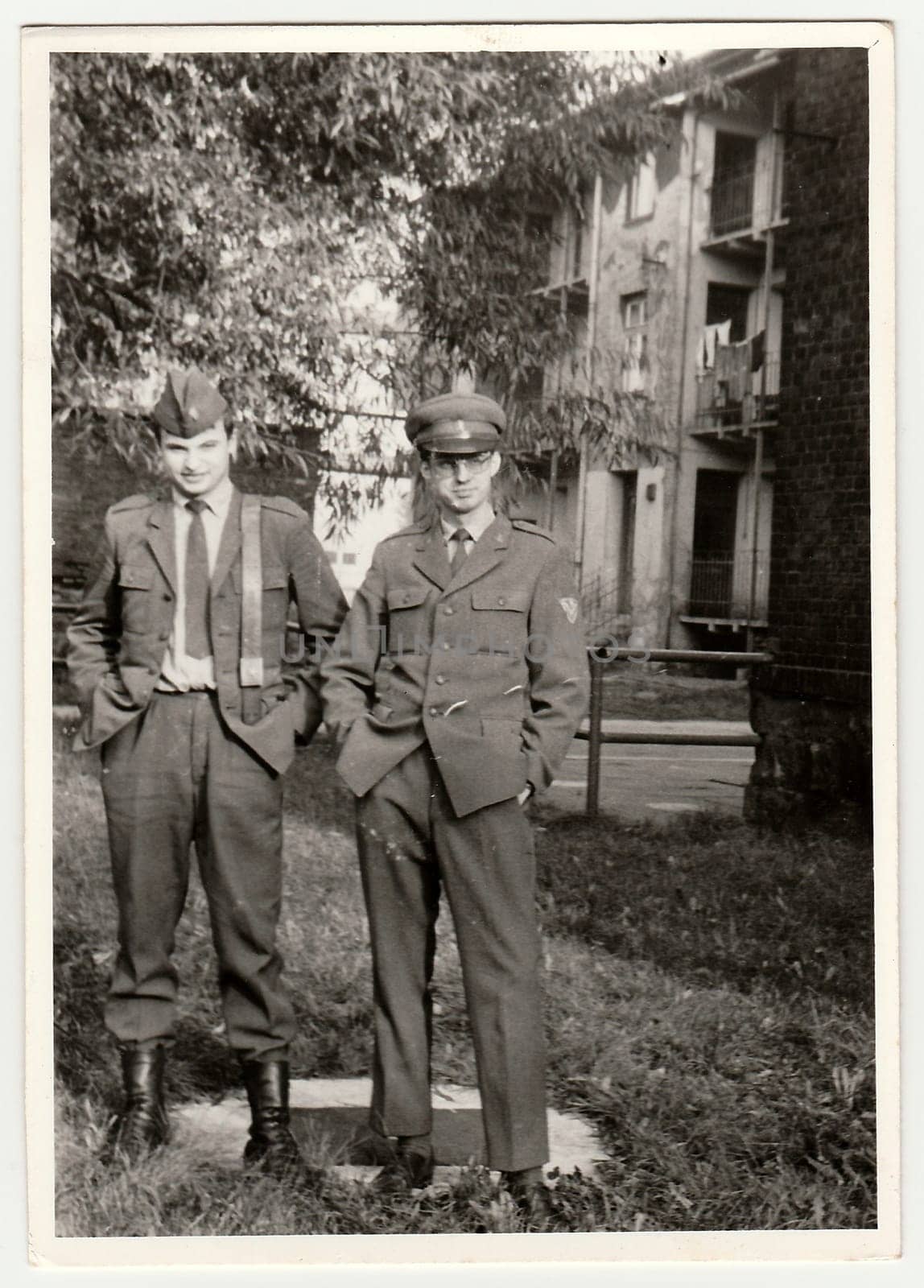 THE CZECHOSLOVAK SOCIALIST REPUBLIC - CIRCA 1970s: Vintage photo shows soldiers pose in front of barracks. Black & white antique photo.