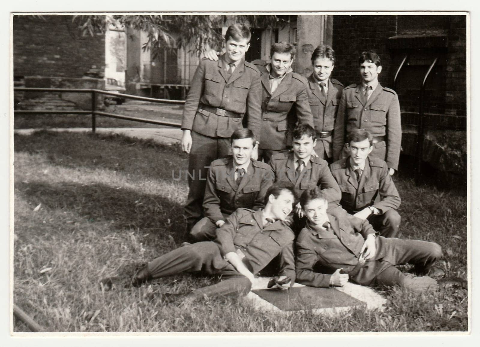 Vintage photo shows soldiers pose in front of barracks. Black & white antique photo. by roman_nerud