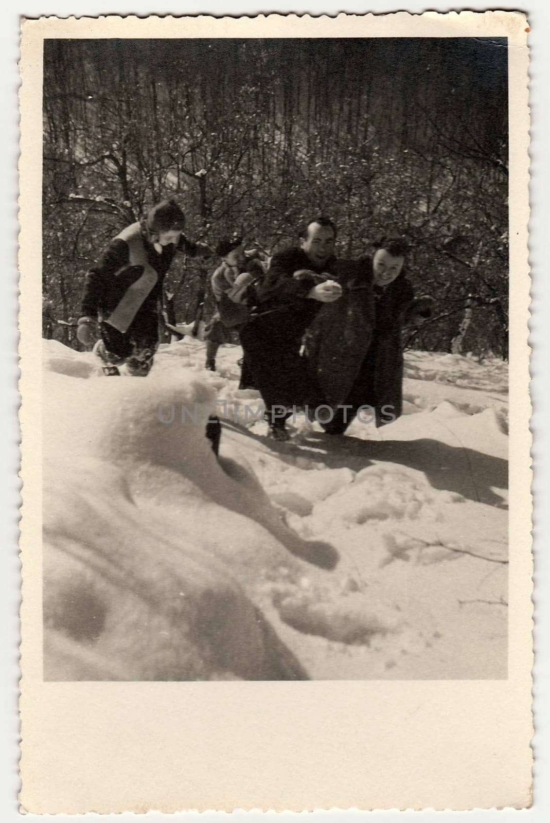 Vintage photo shows people frolic in the snow. Black white antique photography. by roman_nerud