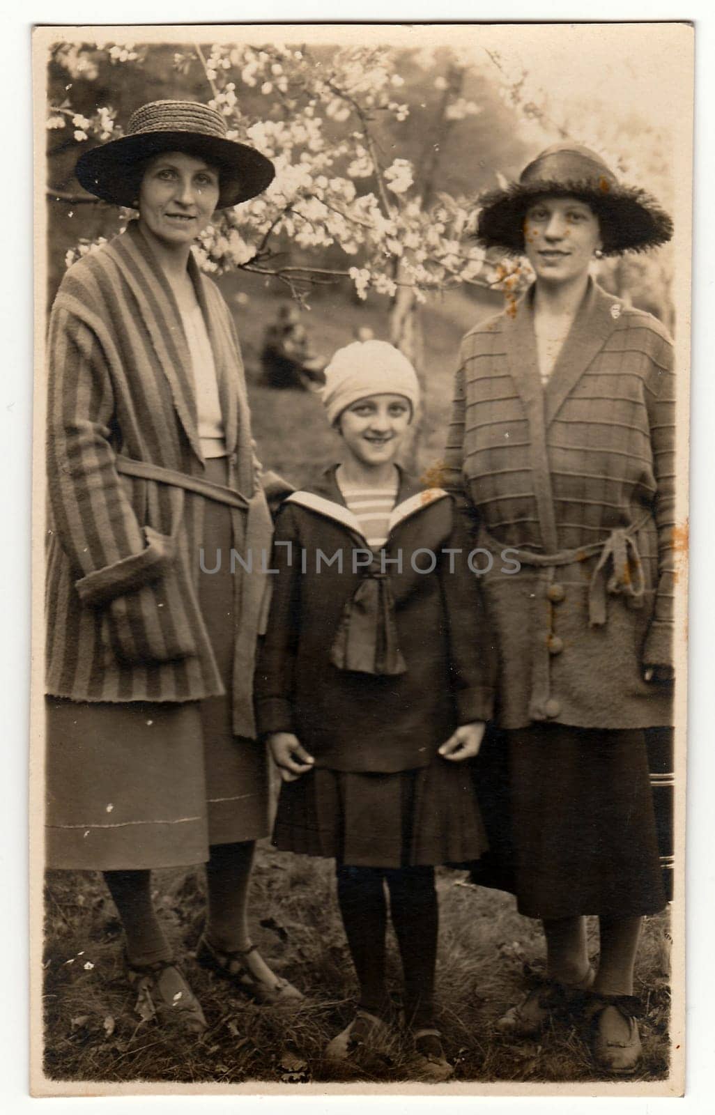 Vintage photo shows elegant women with girl in the garden during spring time. . Black white antique photography. by roman_nerud