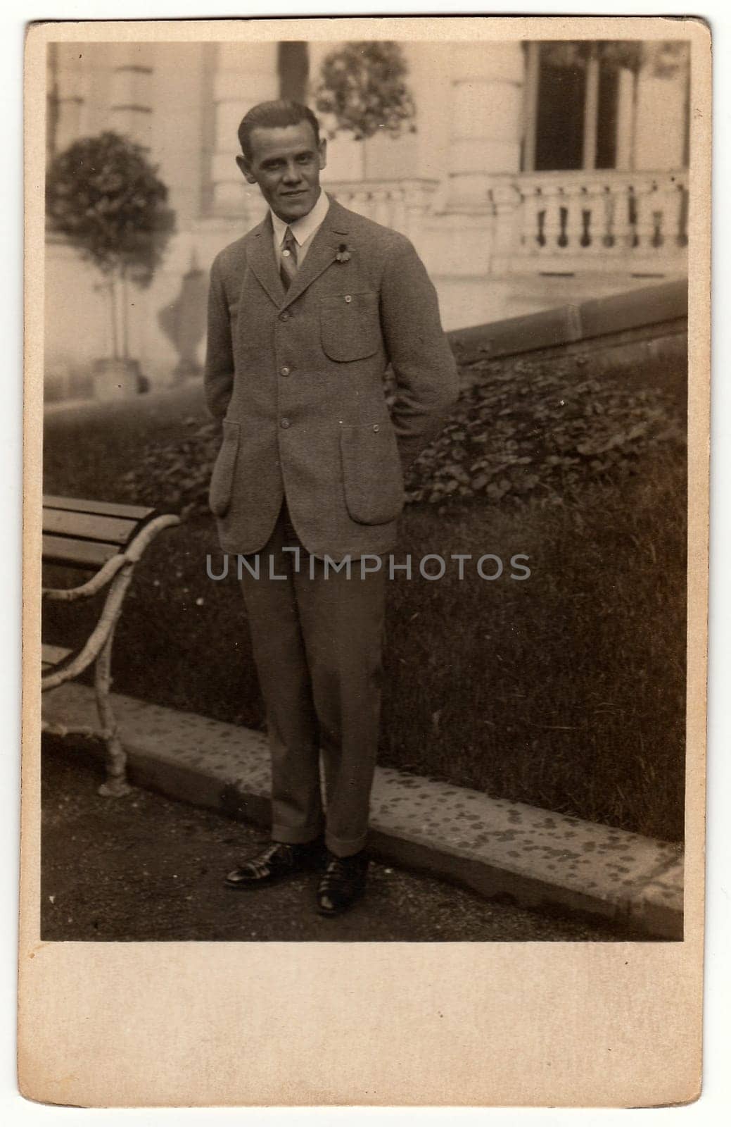 Vintage photo shows man wears an elegant suit, poses in front of castle. Black white antique photography. by roman_nerud