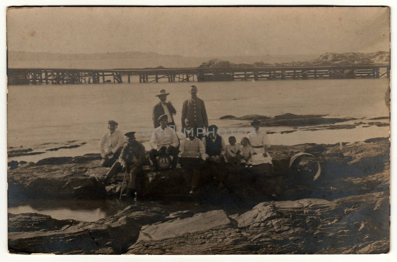 Vintage photo shows people sit at the seashore. Black white antique photography. by roman_nerud