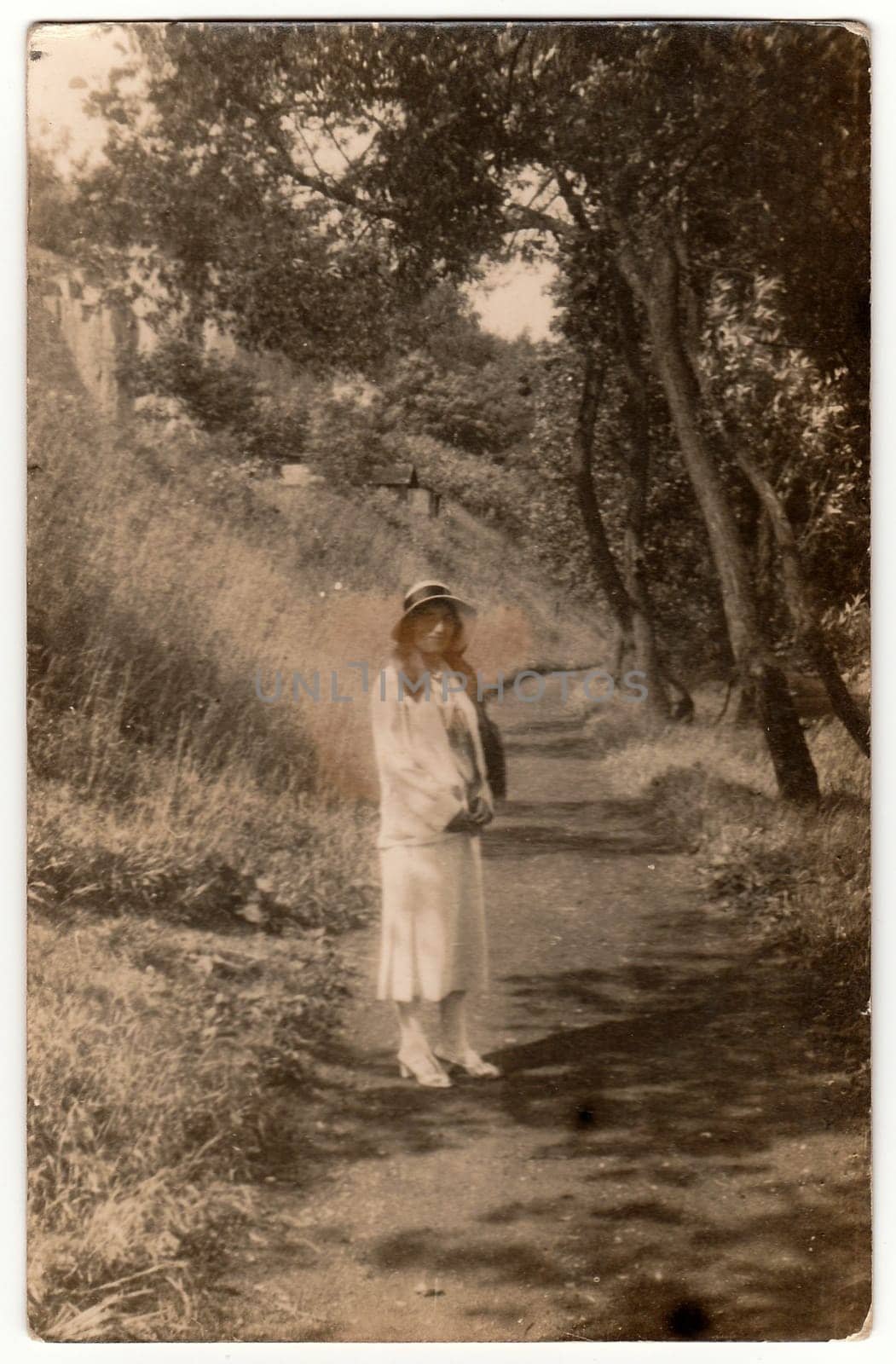 Vintage photo shows young girl outdoors. Black white antique photography. by roman_nerud