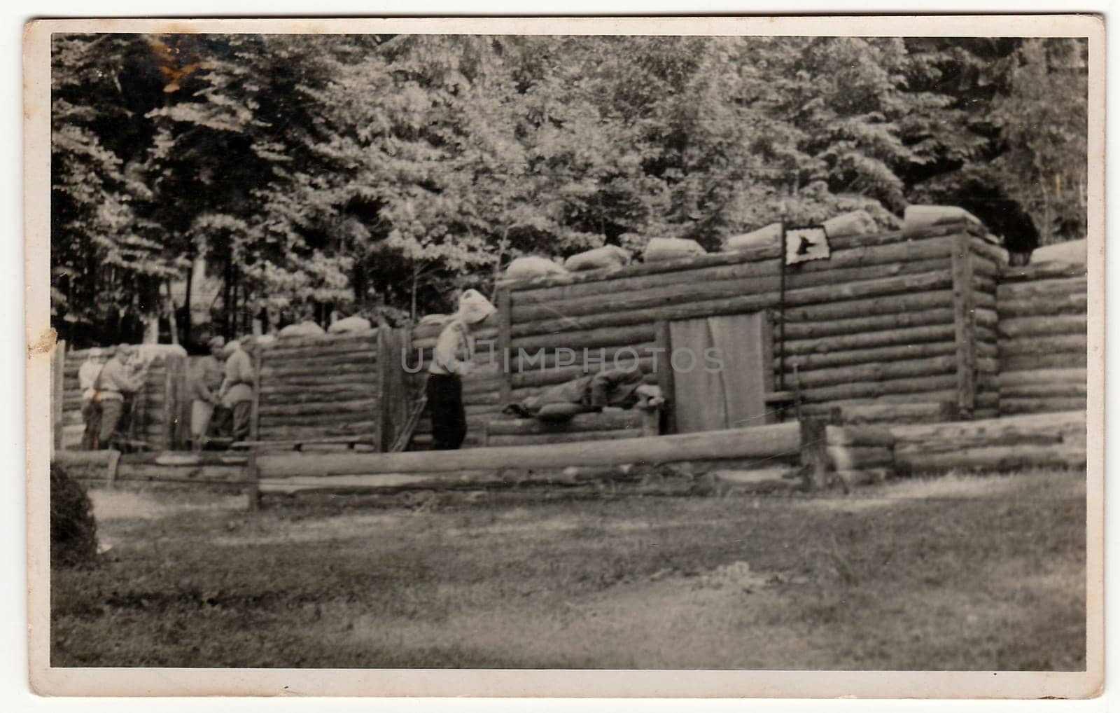 Vintage photo shows soldiers in front of log fortification. Black white antique photography. by roman_nerud