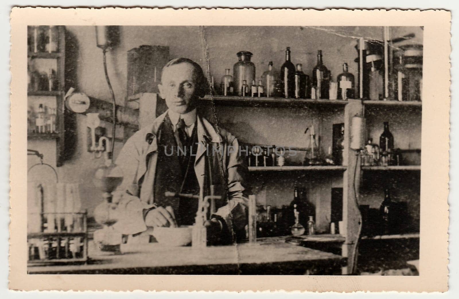 Vintage photo shows man in the chemistry laboratory. Black white antique photography. by roman_nerud