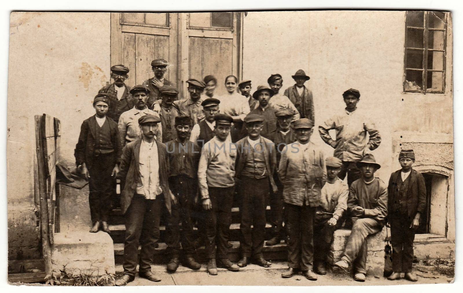 Vintage photo shows rural people pose in front of country house. Black white antique photography. by roman_nerud