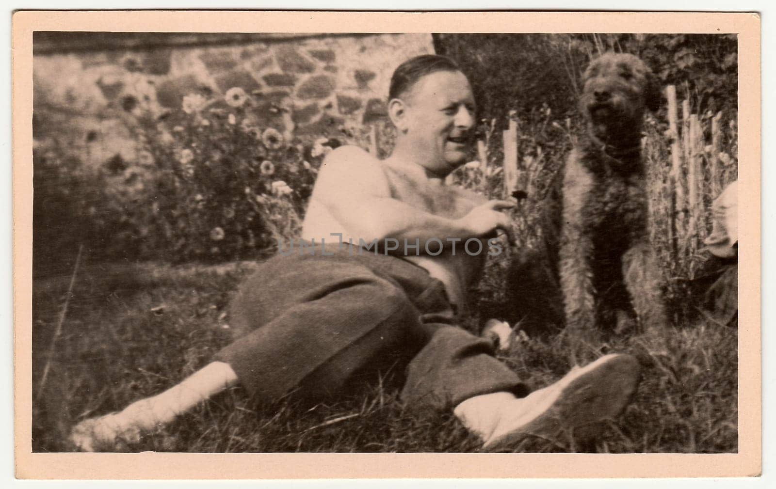 THE CZECHOSLOVAK SOCIALIST REPUBLIC - CIRCA 1960s: Vintage photo shows man with dog outdoors. Black white antique photography.