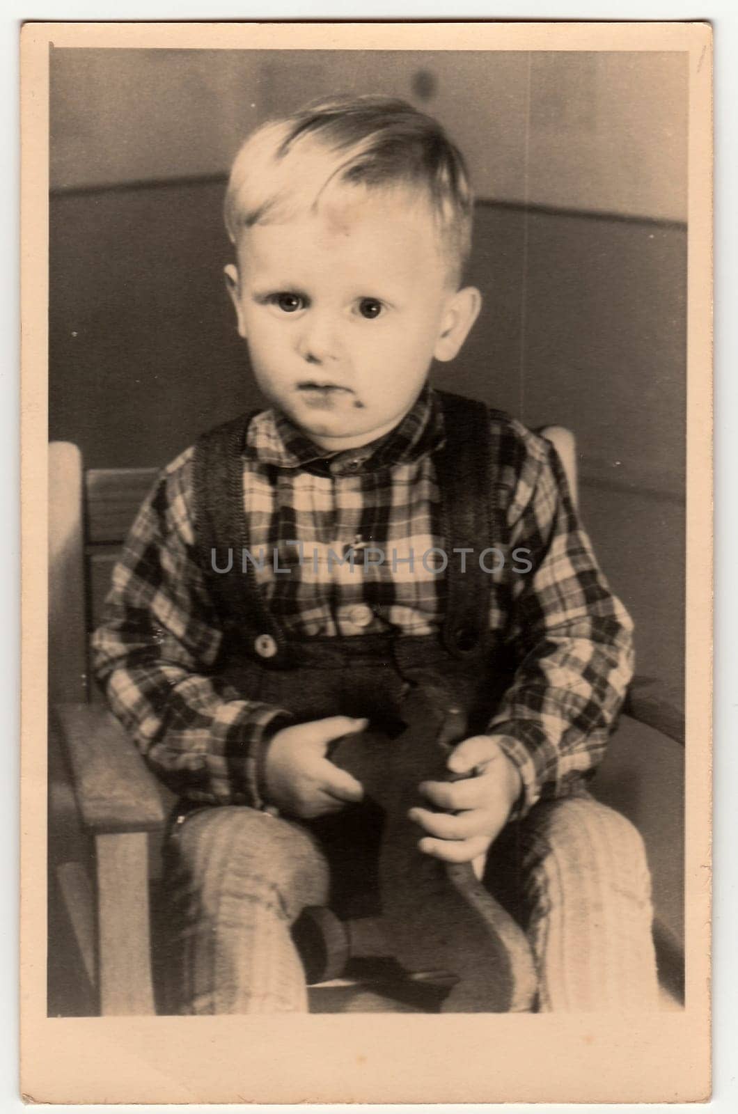 Vintage photo shows a small boy with wooden toy. Antique black white photography. by roman_nerud