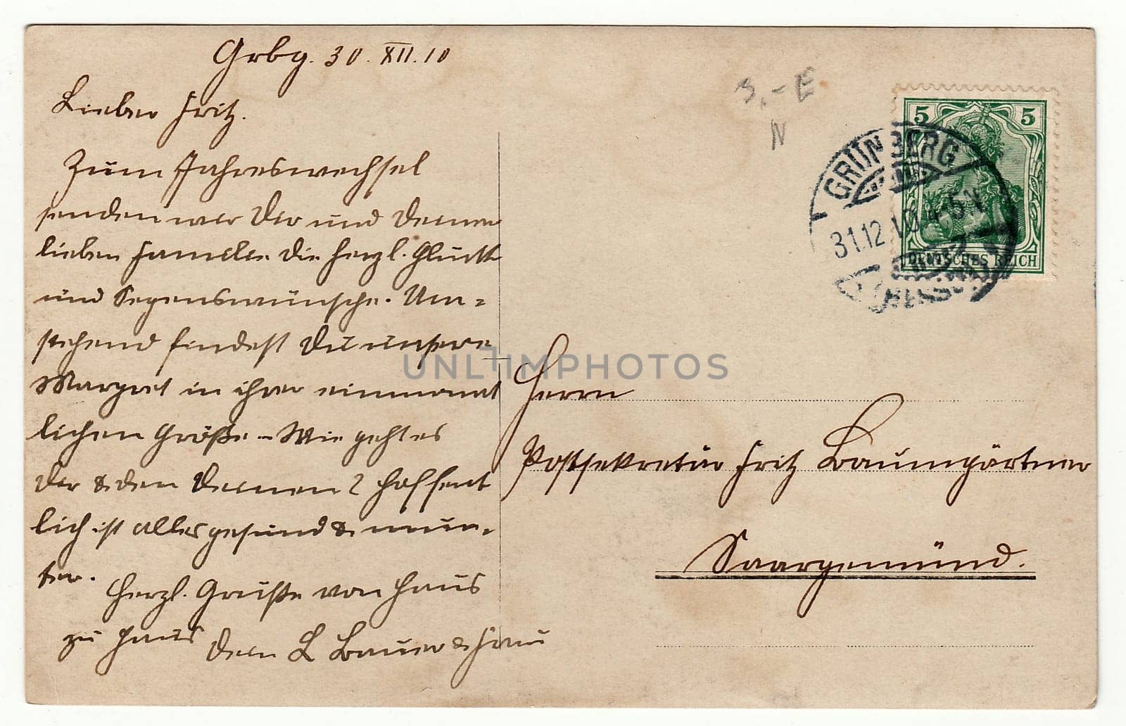 GERMANY - DECEMBER 30, 1910: Back of a vintage photo - used postcard. Rich stain and paper details. Can be used as background. Image contains handwriting.