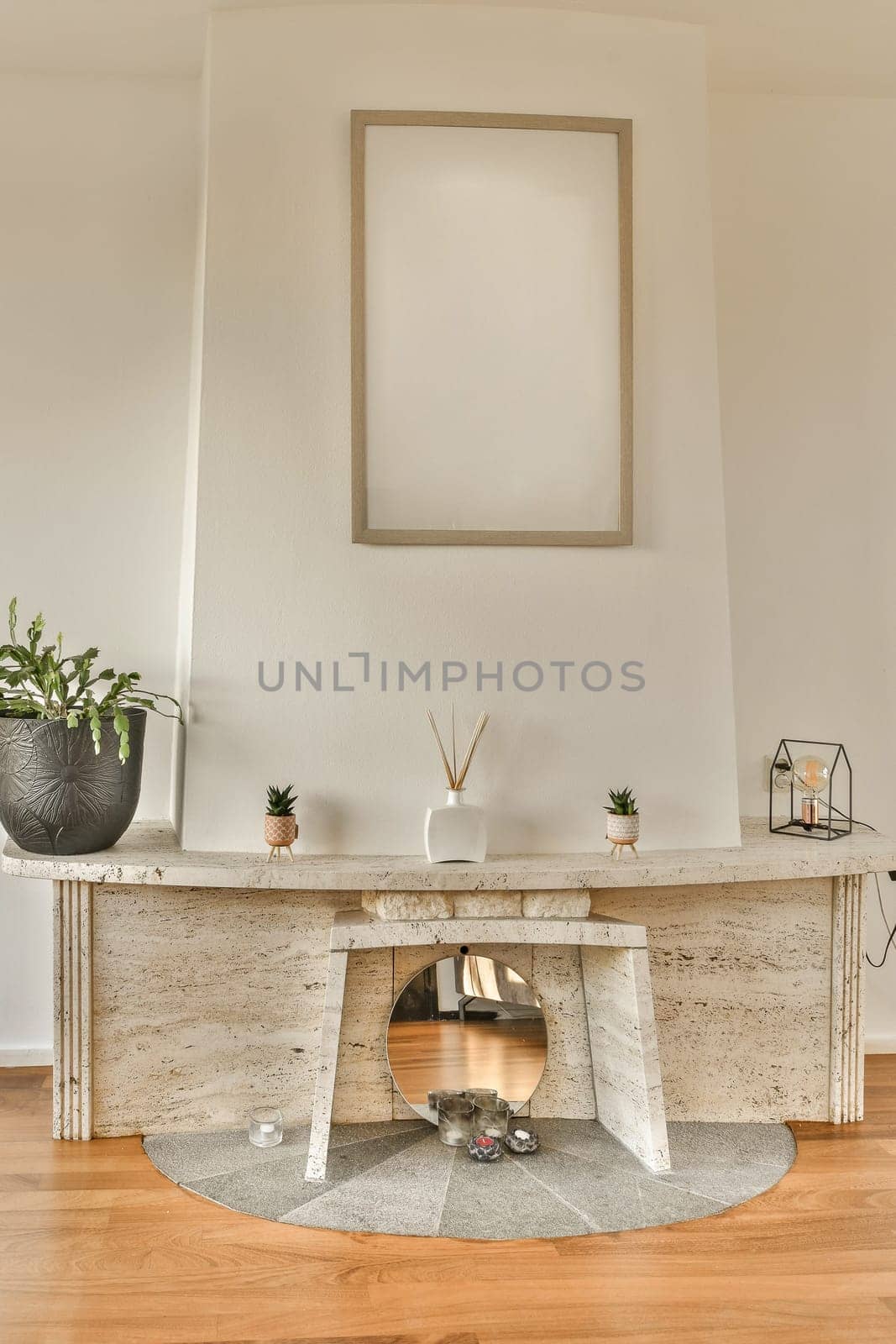 a fireplace in the corner of a room with wood flooring and white walls behind it is a large mirror