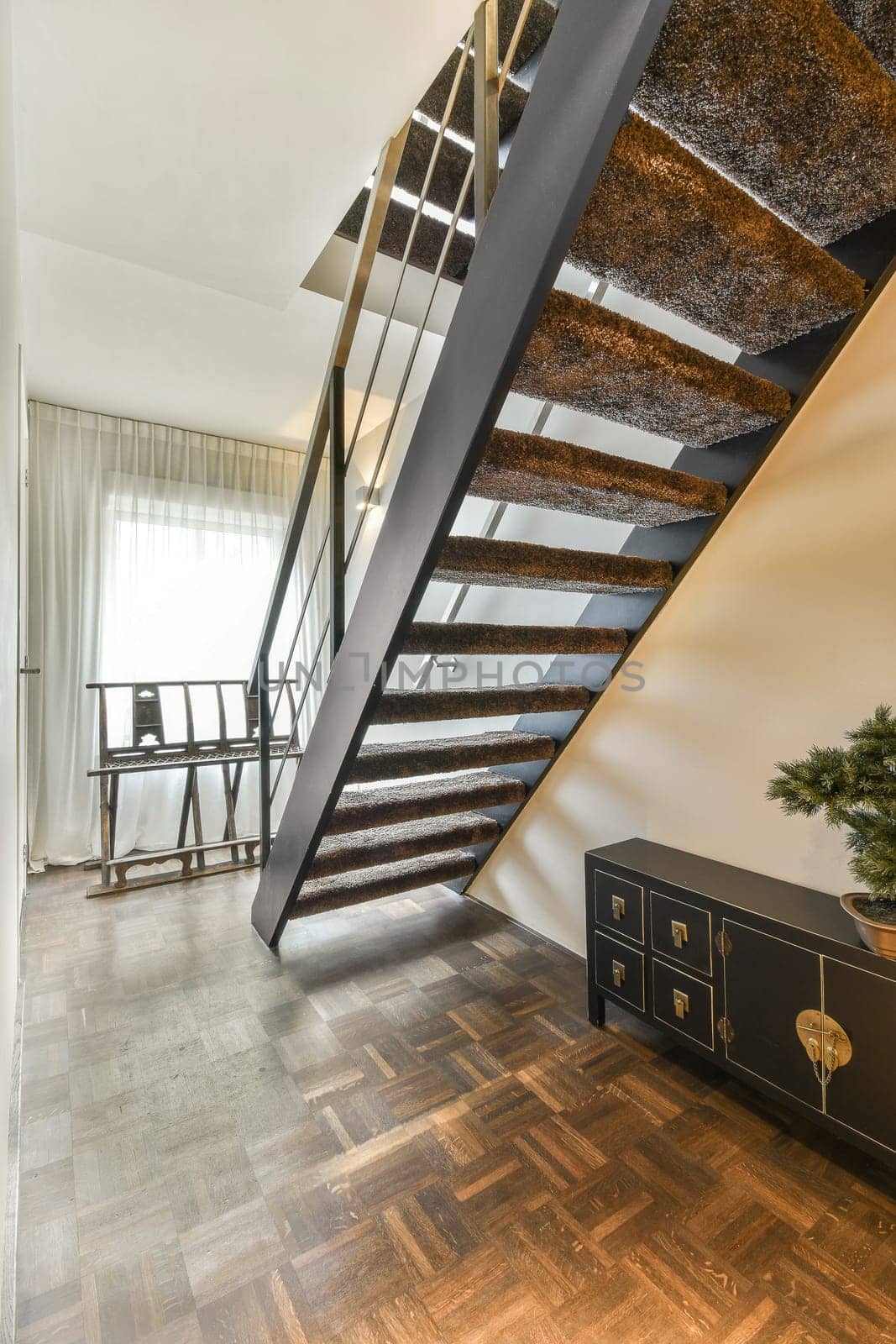 a staircase with a metal railing and a wooden floor by casamedia