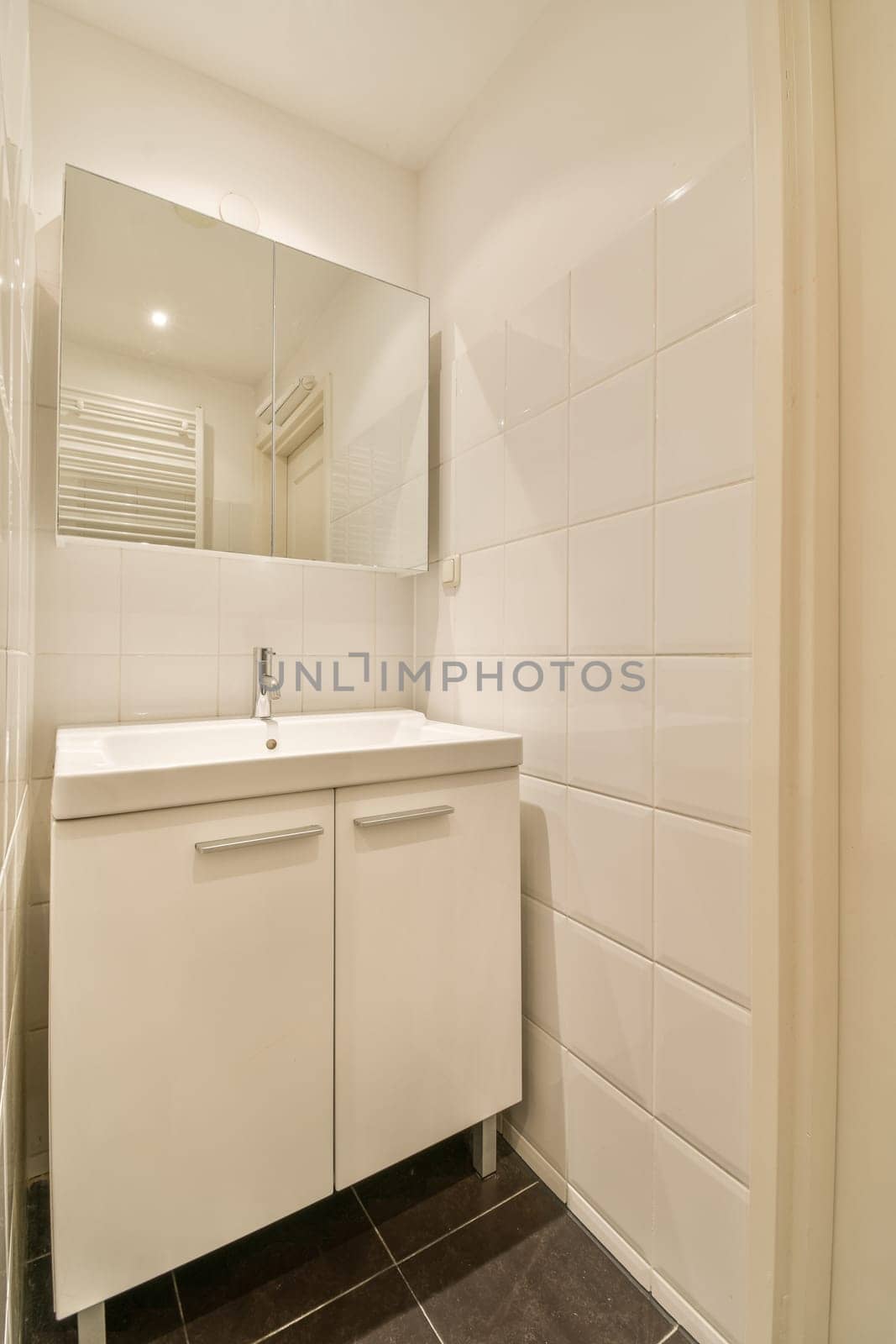 a white bathroom with a sink and a mirror by casamedia