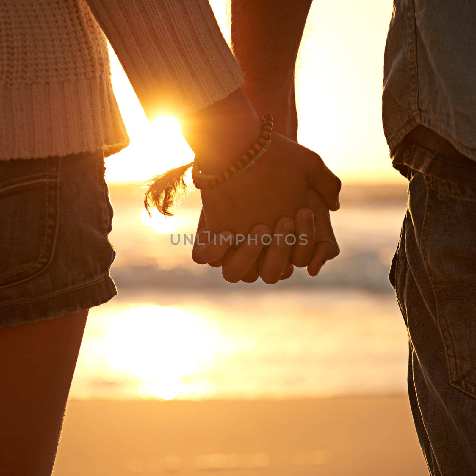 100 committed. Closeup shot of a couple holding hands at sunset. by YuriArcurs