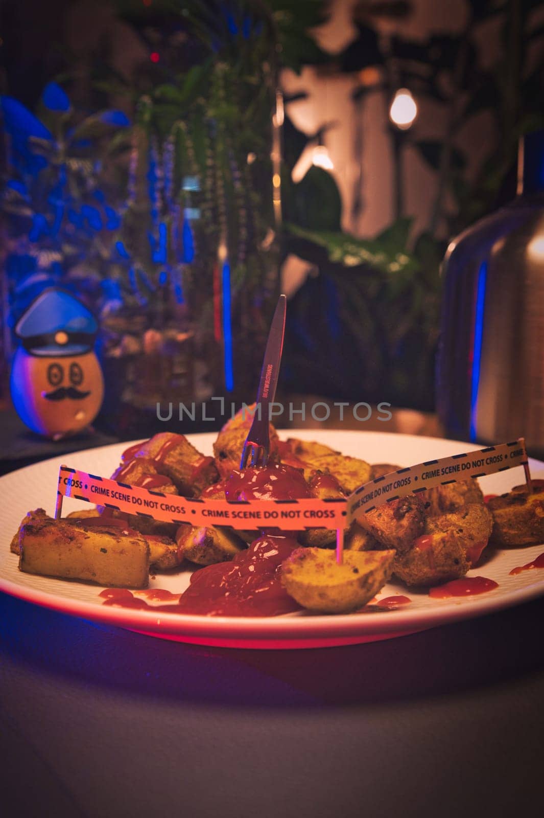 Potato dressed as a policeman in front of a plate with potato wedges shown as a crime scene
