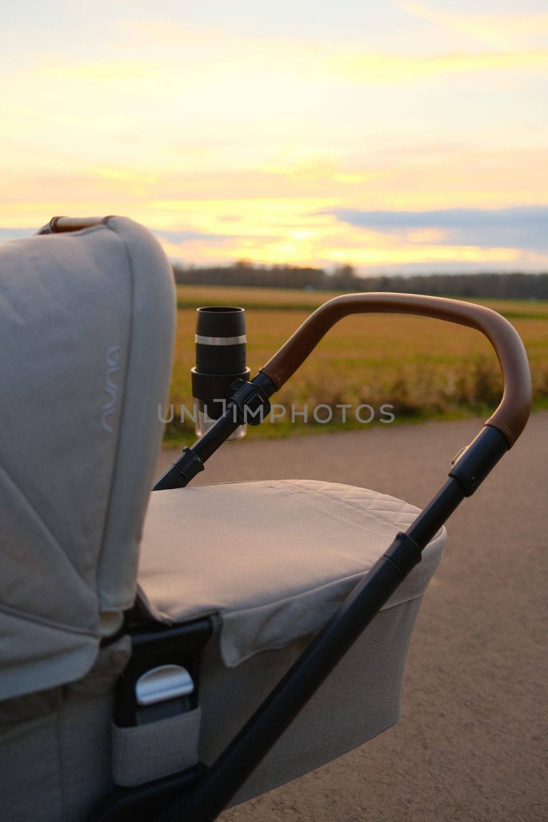 Nuna brand baby stroller near a field against sunset sky by rherrmannde