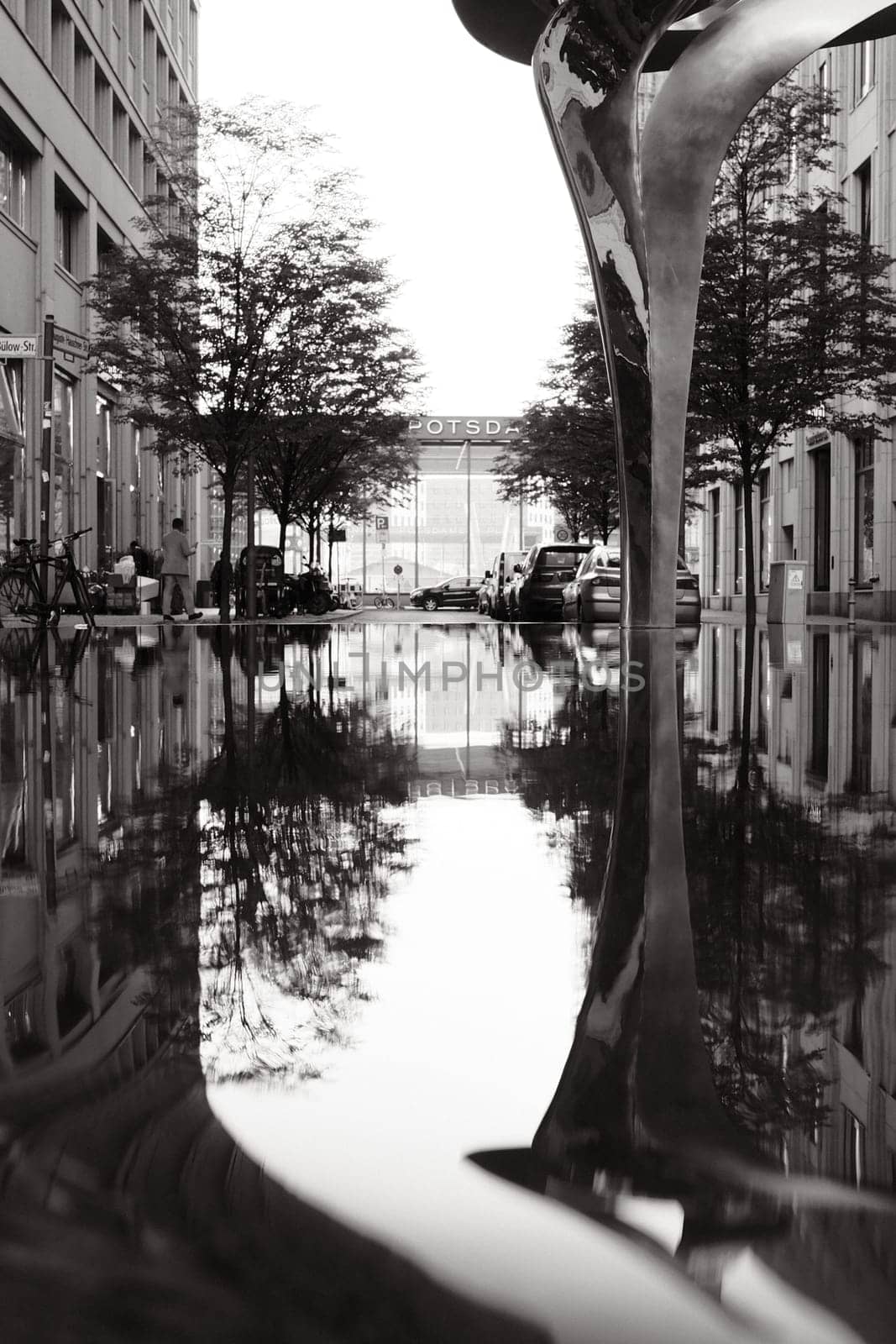 Vertical shot of the reflection of a sculpture in the water near Potsdamer Platz