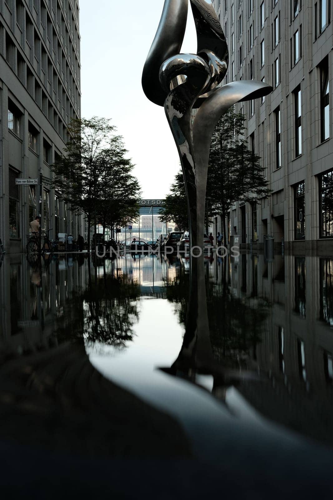 Vertical shot of the reflection of a sculpture in the water near Potsdamer Platz