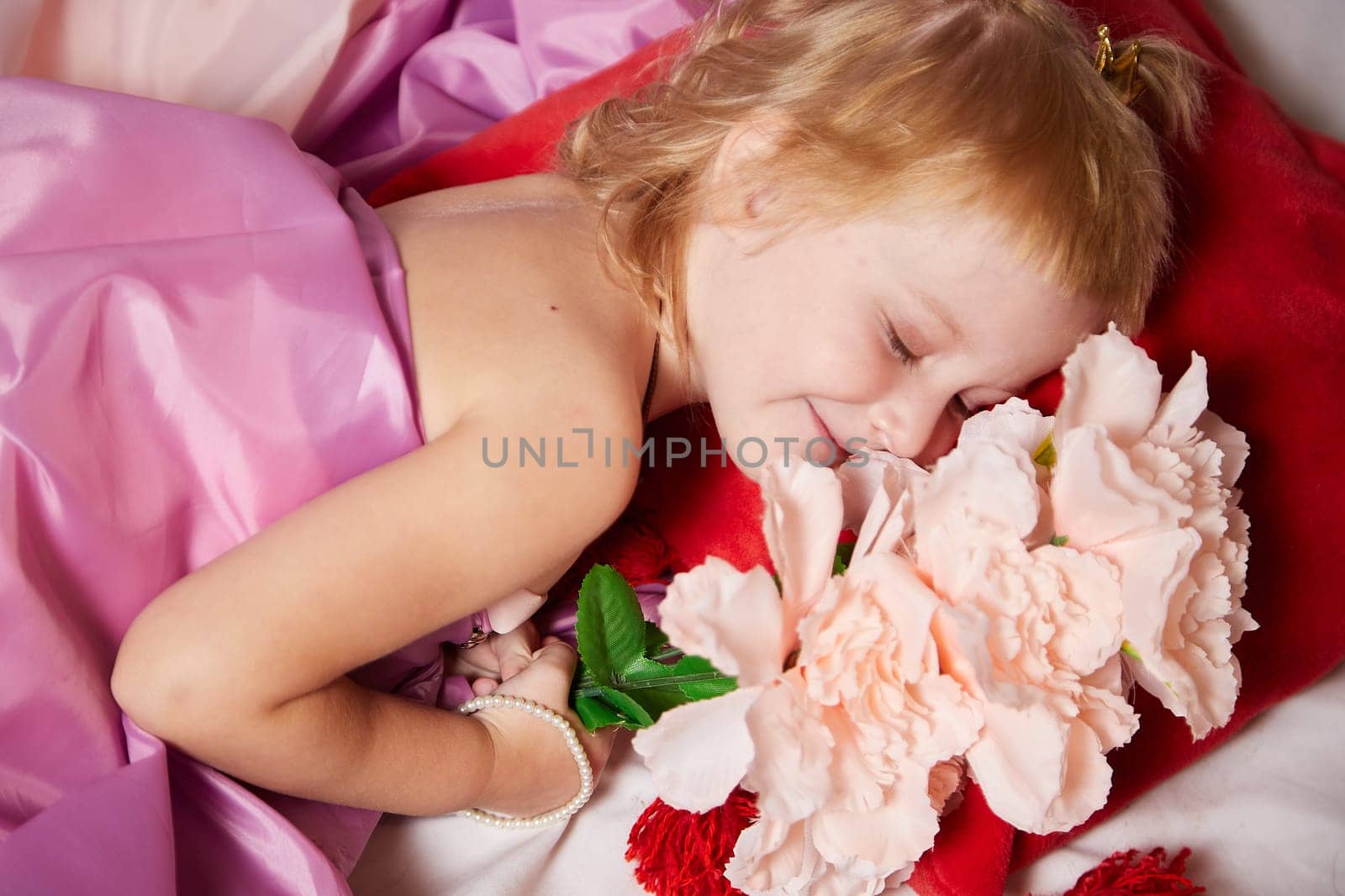 Portrait of cute kid girl posing in pink beautiful dress on a white background. Young female model looking as magic princess from fairy taly by keleny