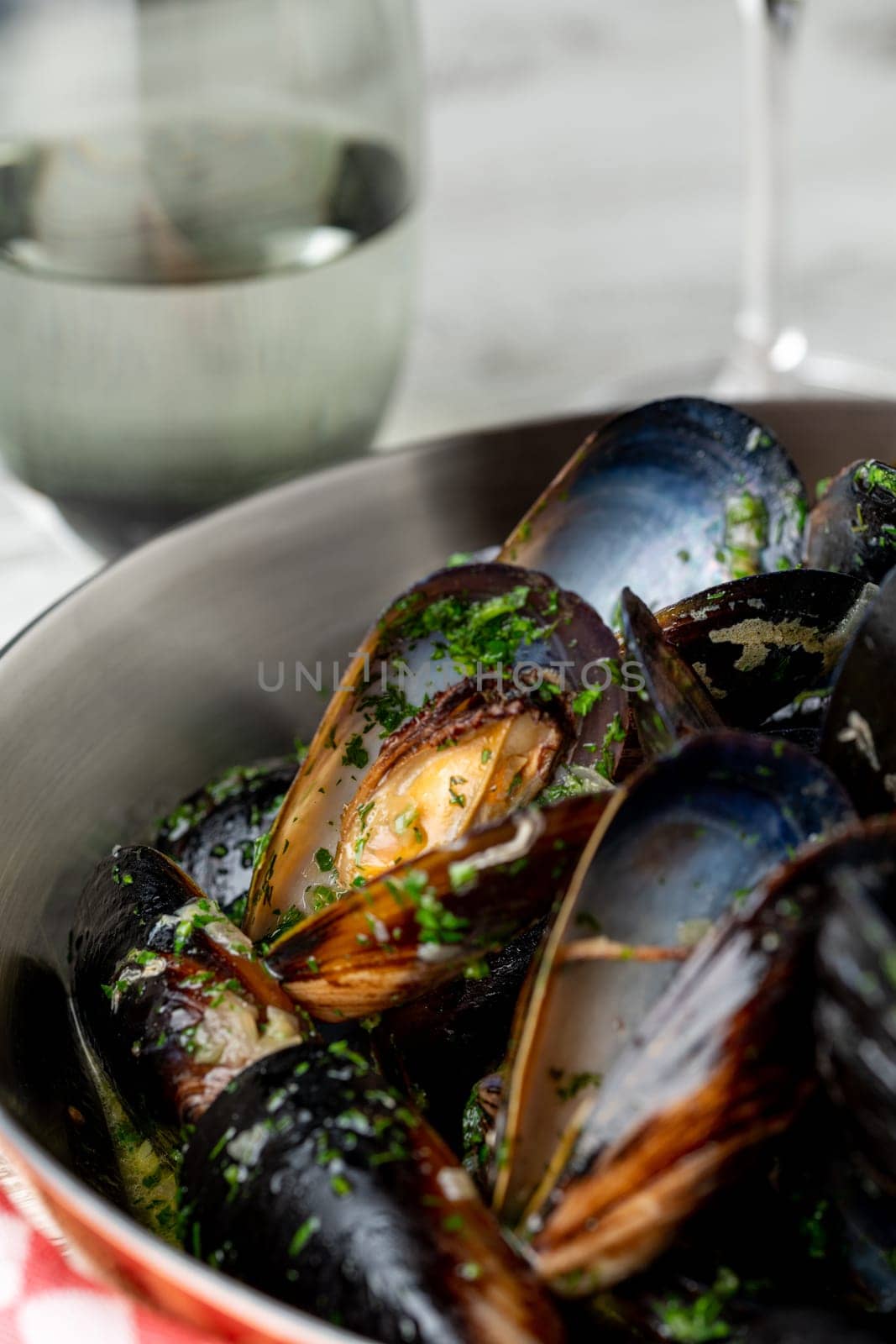 Baked blue mussels in spicy with lemon in a black cast-iron pot