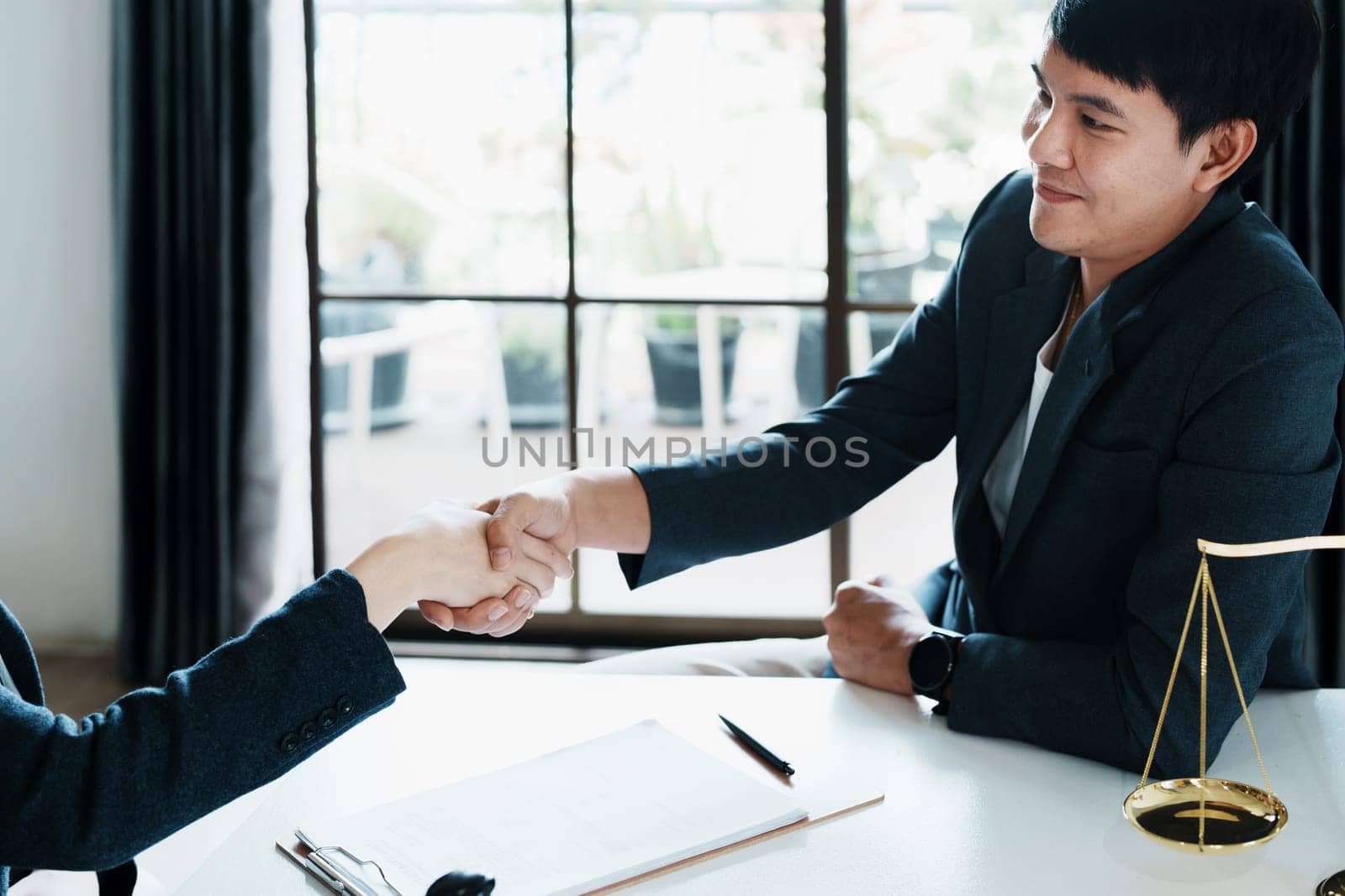 Law, consultation, agreement, contract, lawyer or attorney shakes hands to agree on the client's offer to be hired to fight the parties in court. by Manastrong